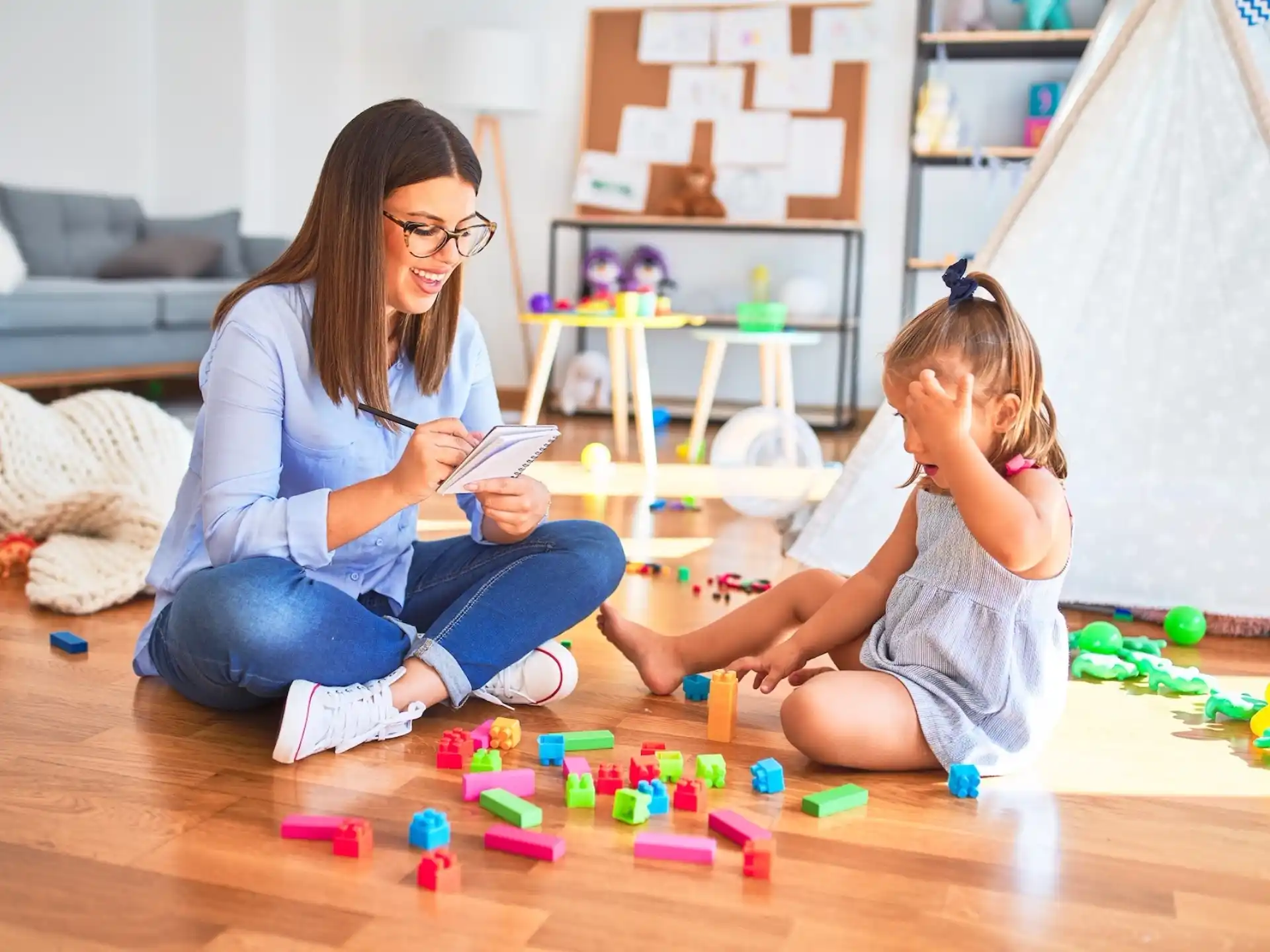 a woman and a child playing with toys on the floor