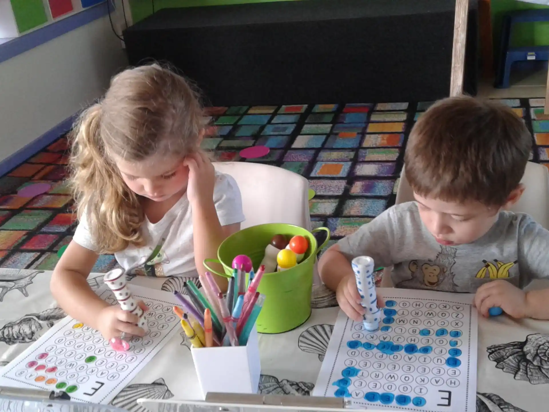 a boy and girl sitting on the floor playing with toys