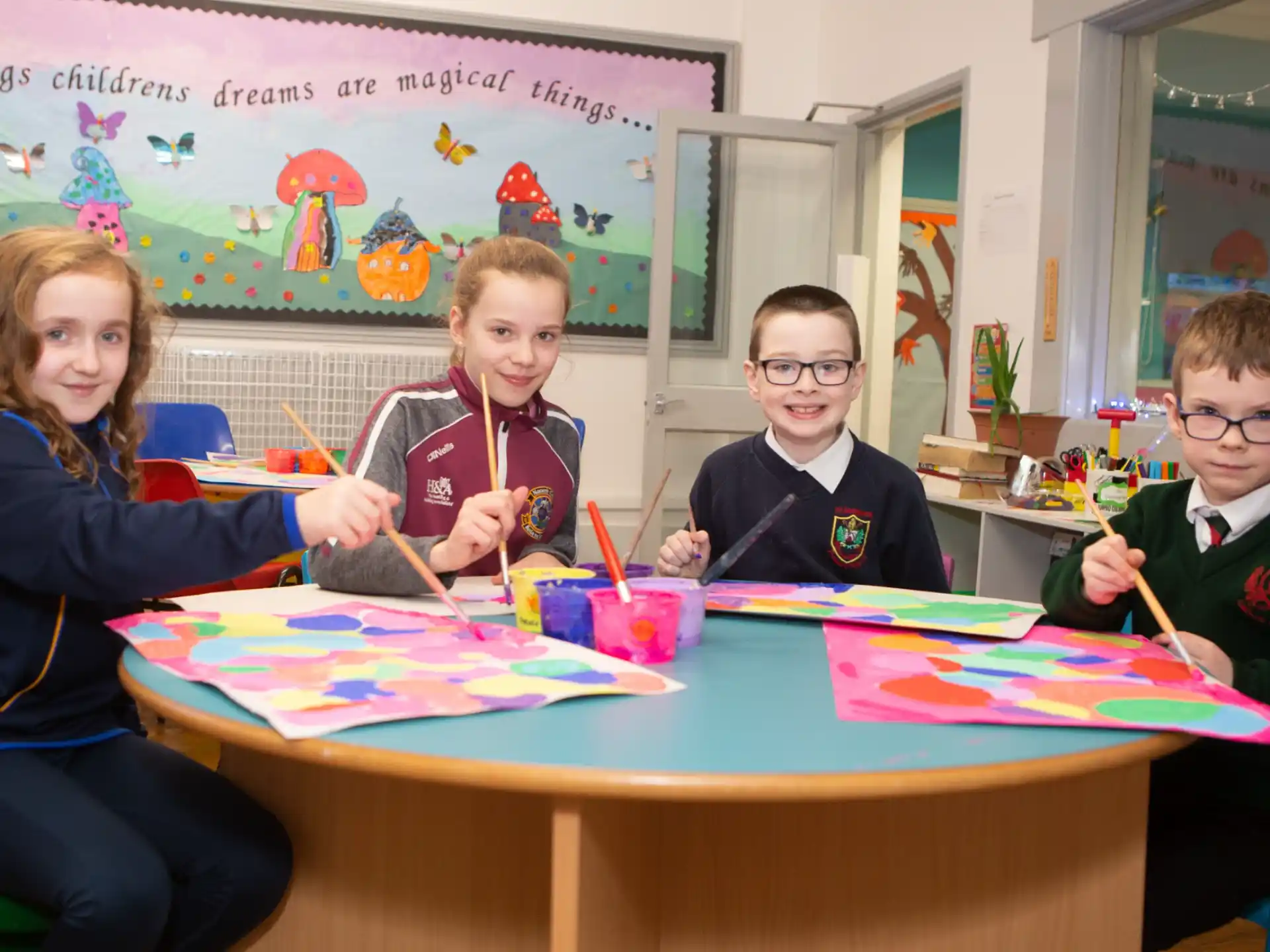 a group of children sitting at a table with a board game