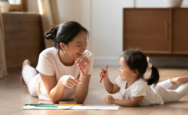 a person and a child writing on paper