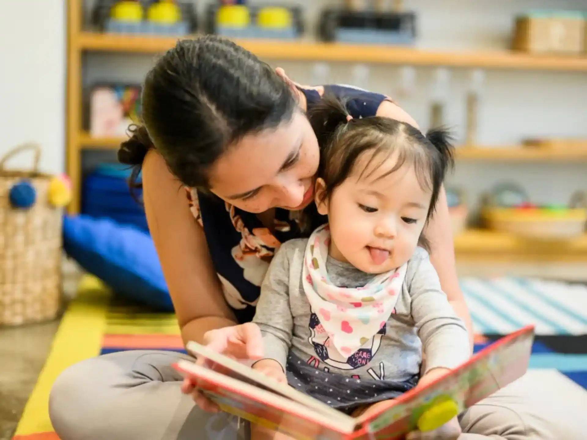 a person reading a book to a young girl