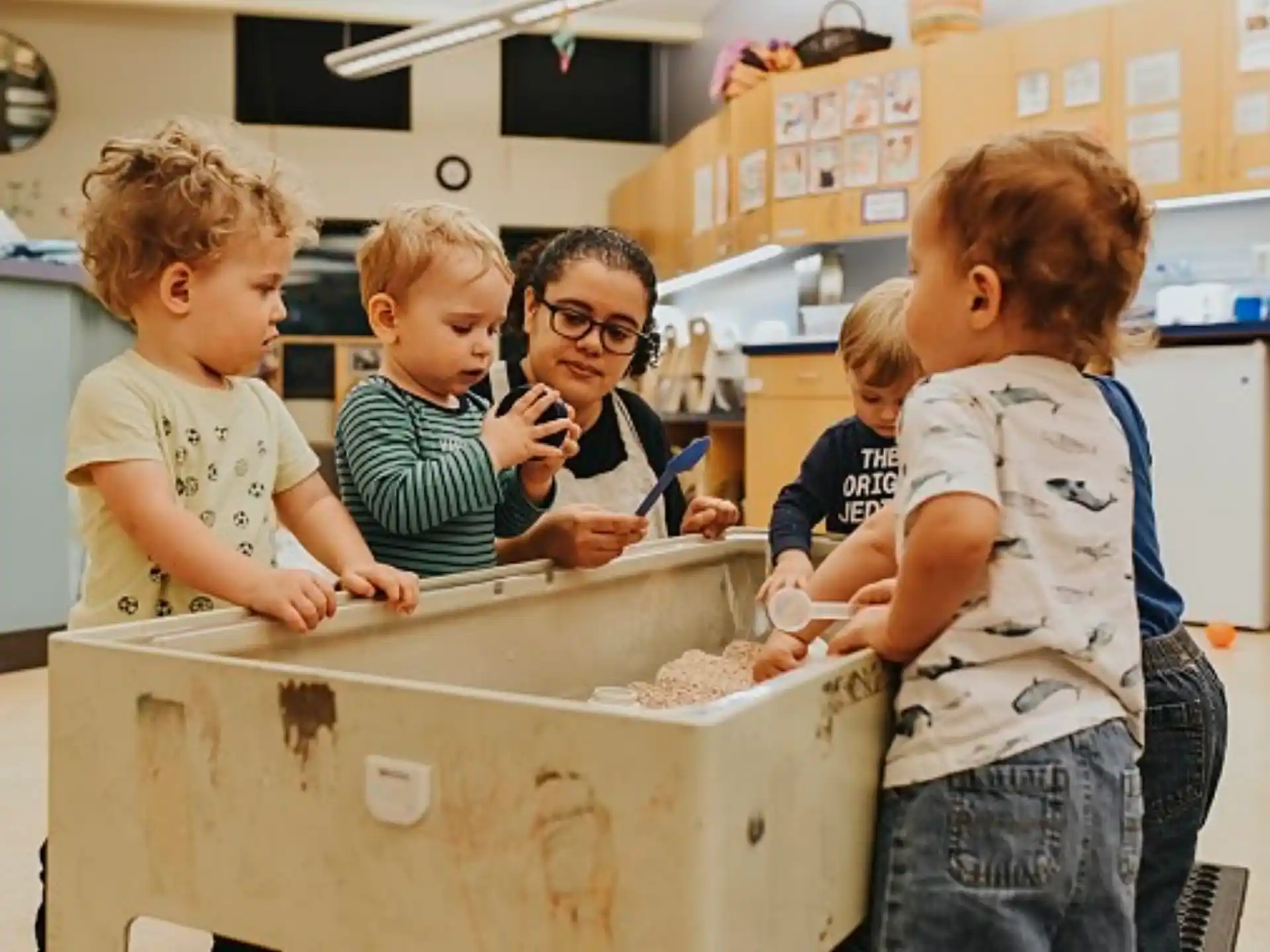 a group of kids looking at a white box