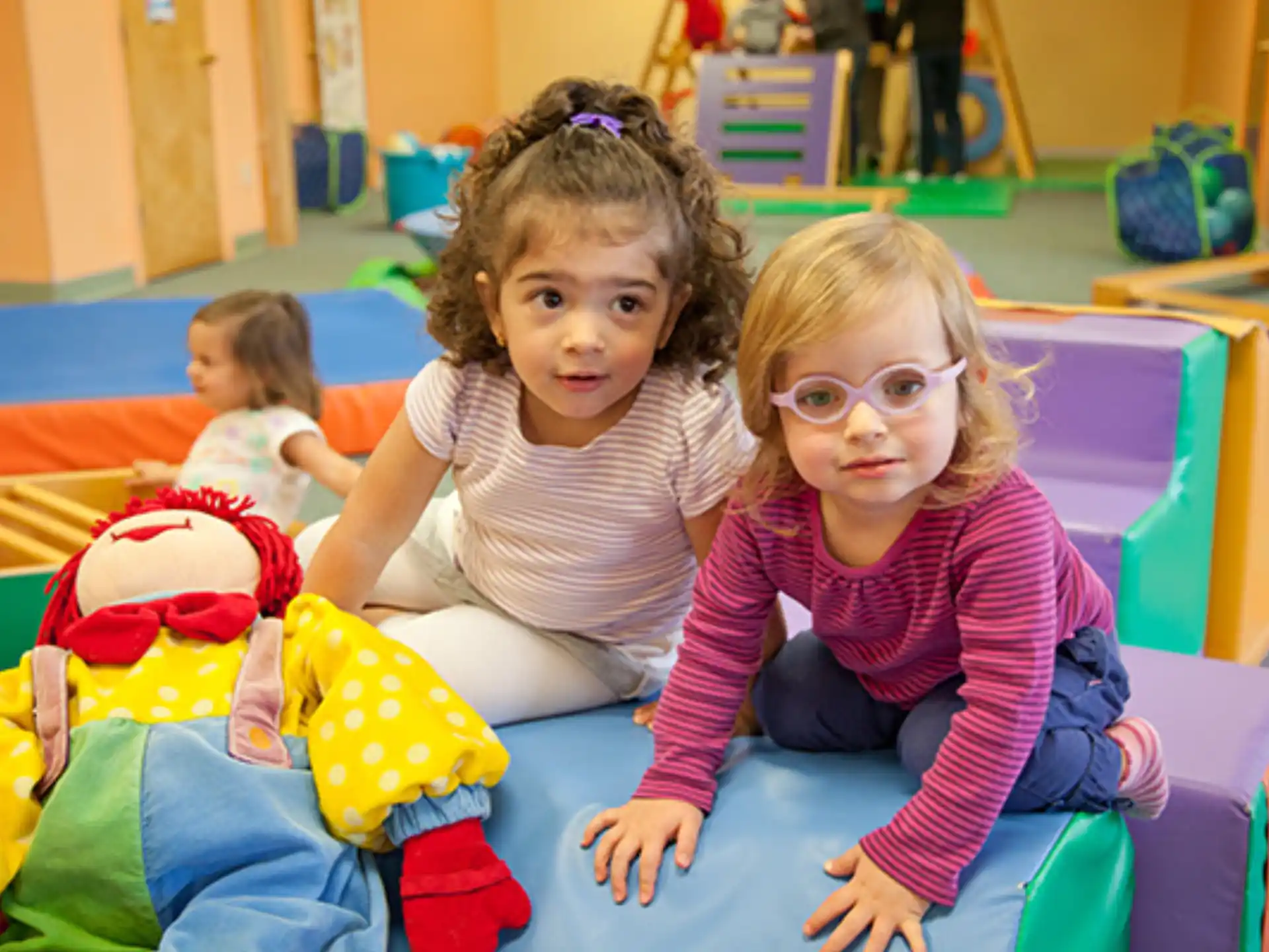a group of children sitting on a colorful mat