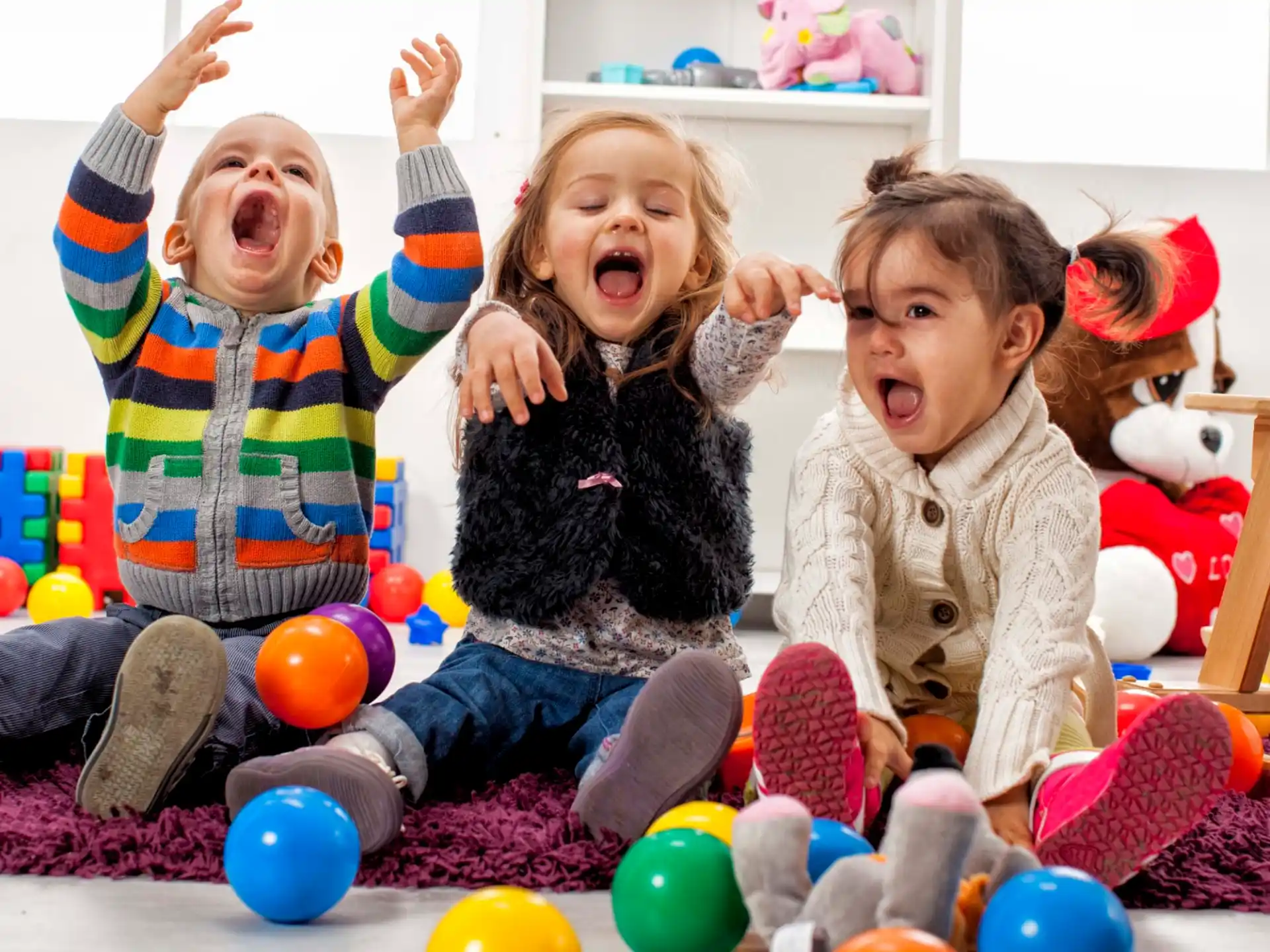 a group of children sitting on the floor with their mouths open