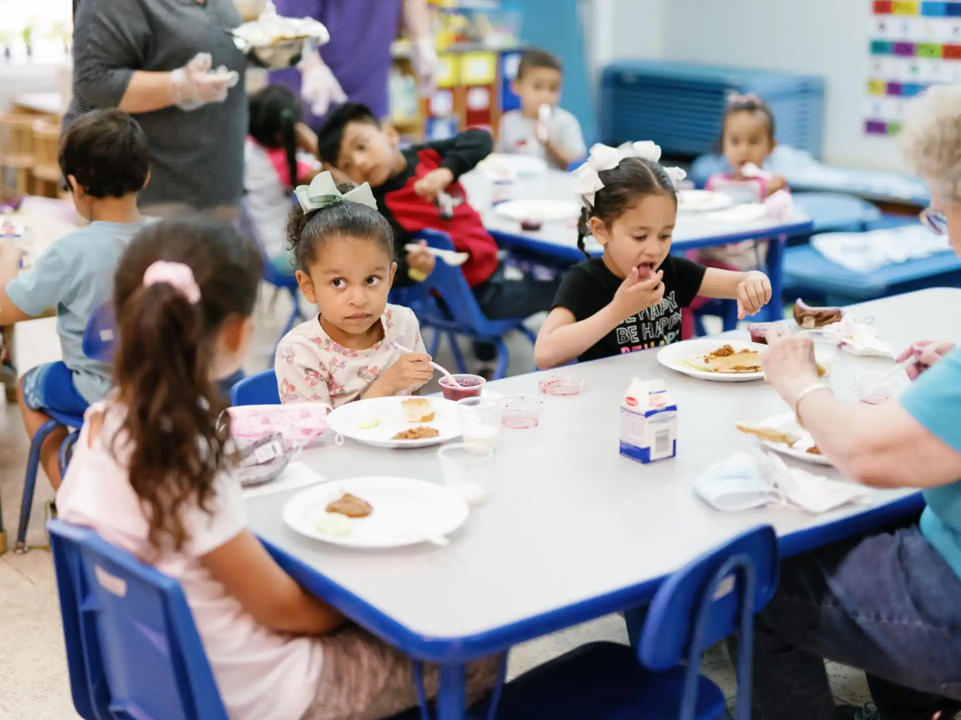 a group of children eating at a table