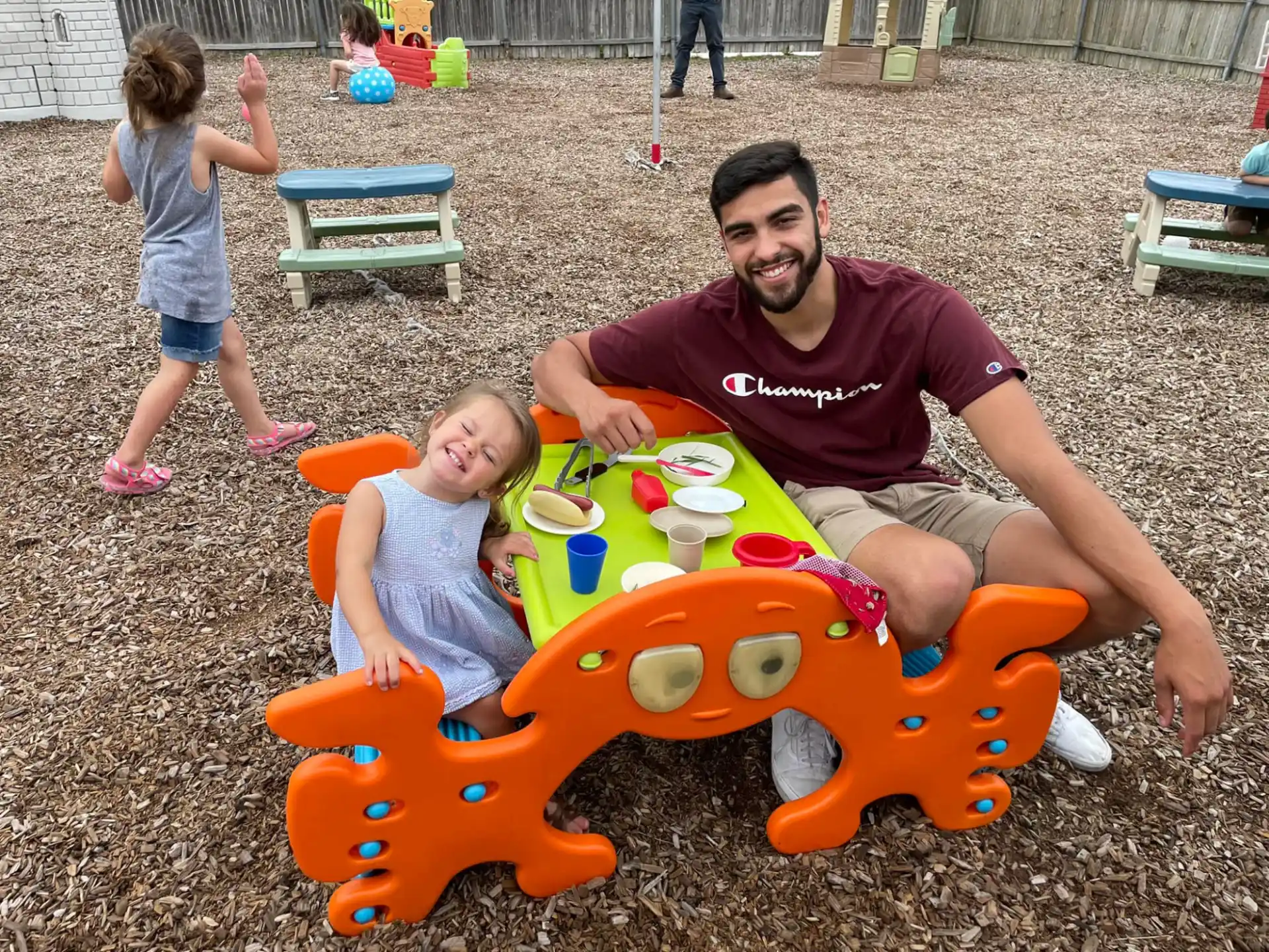 a person and two children playing in a sandbox