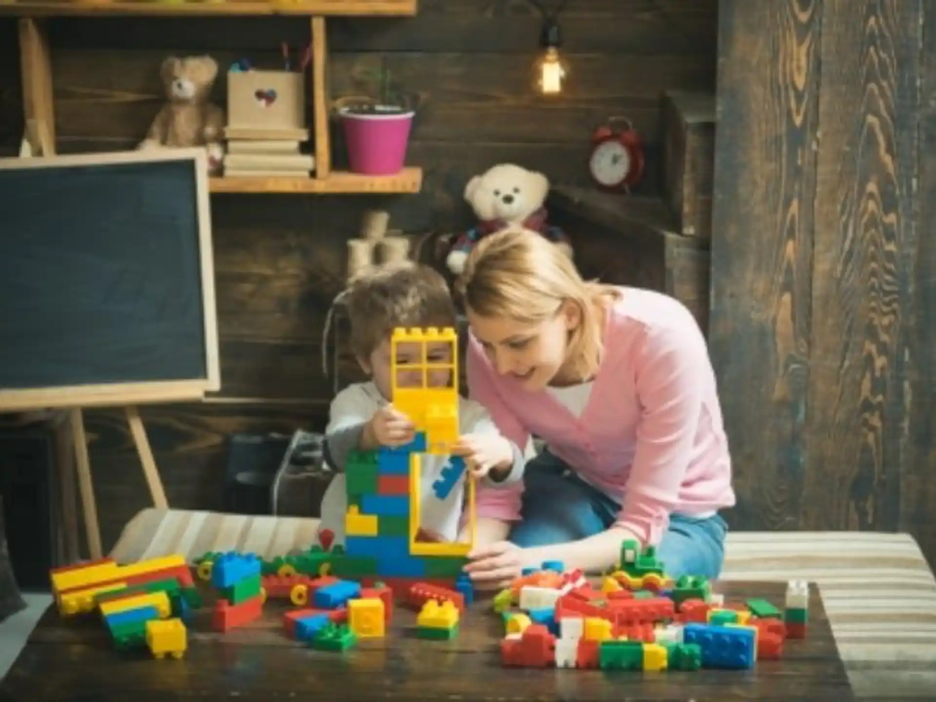 a person and a child playing with toys on a table