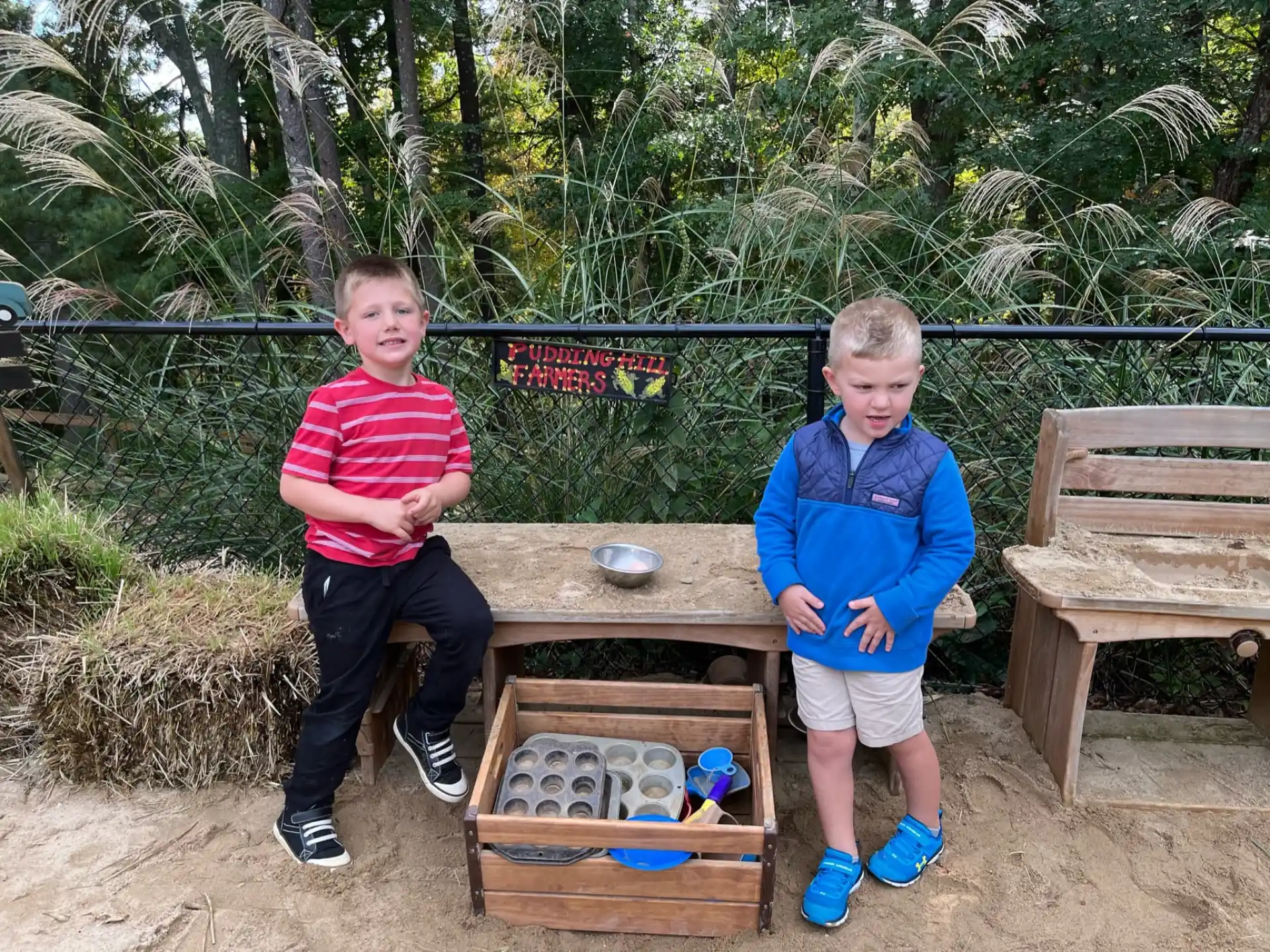 two boys standing next to a table
