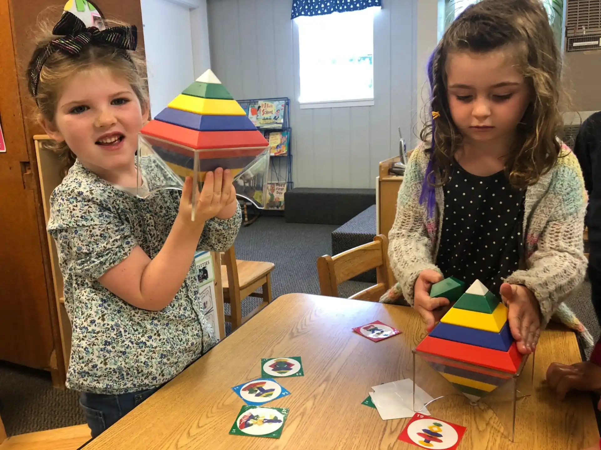 a couple of young girls playing with toys on a table
