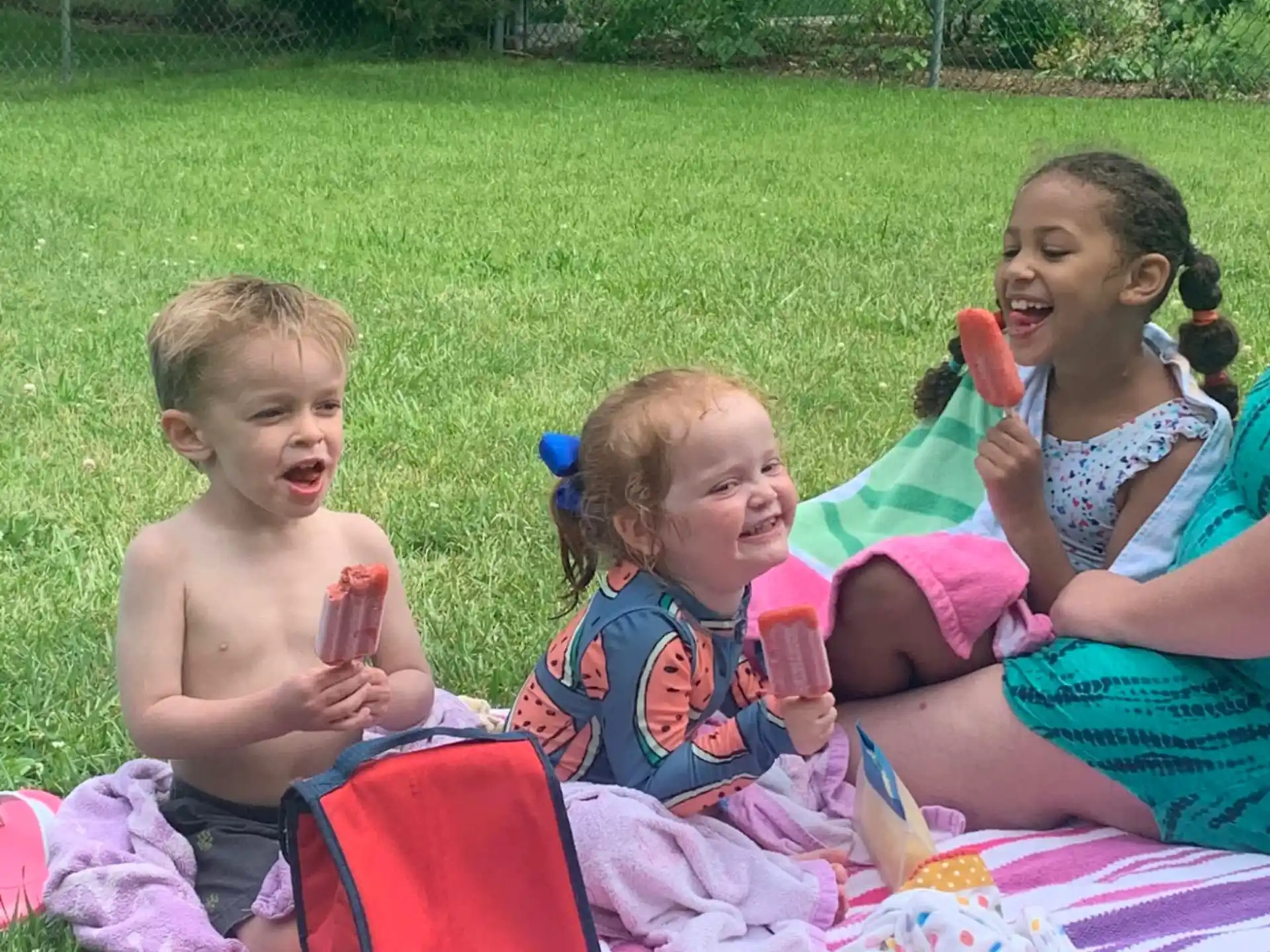 a group of children sitting on the grass