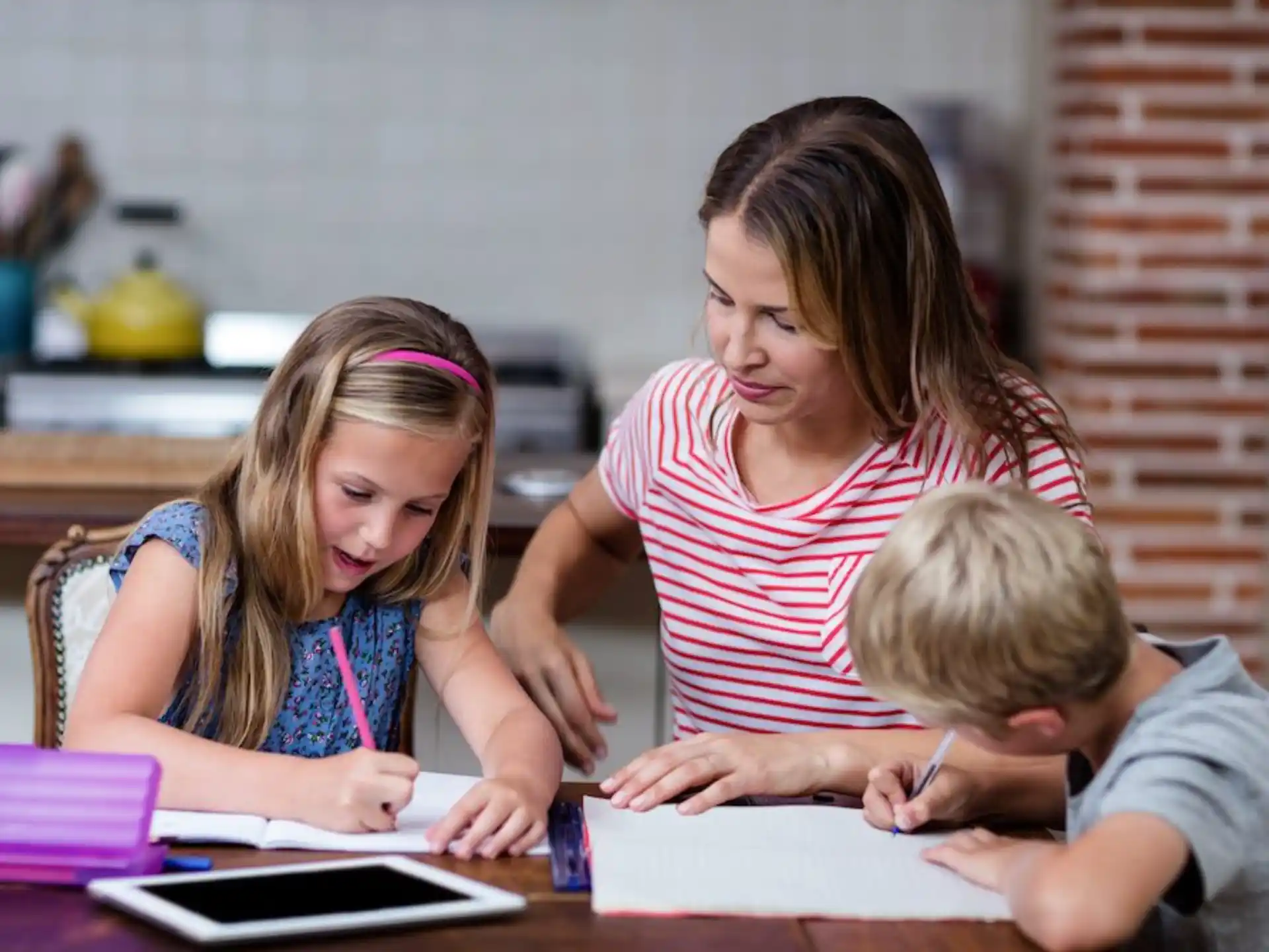 a person and a couple of children sitting at a table
