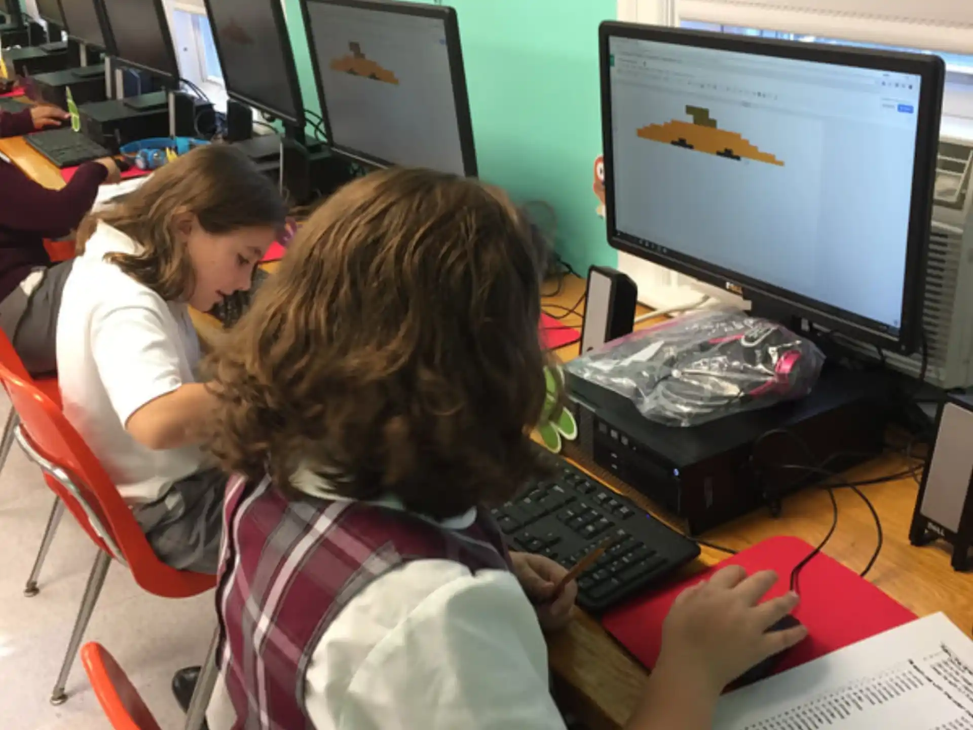 a few young girls working on computers