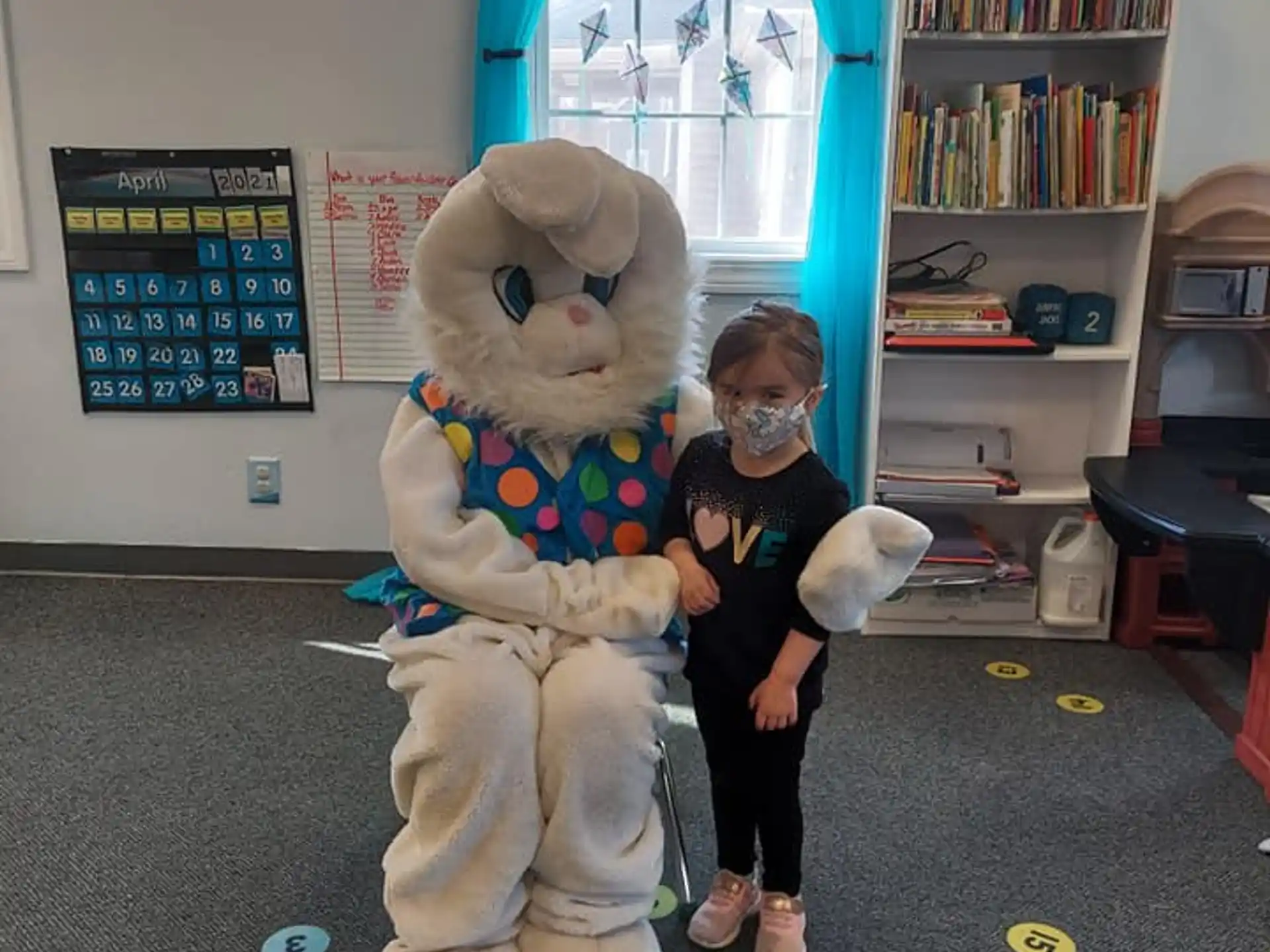 a child standing next to a person in a garment