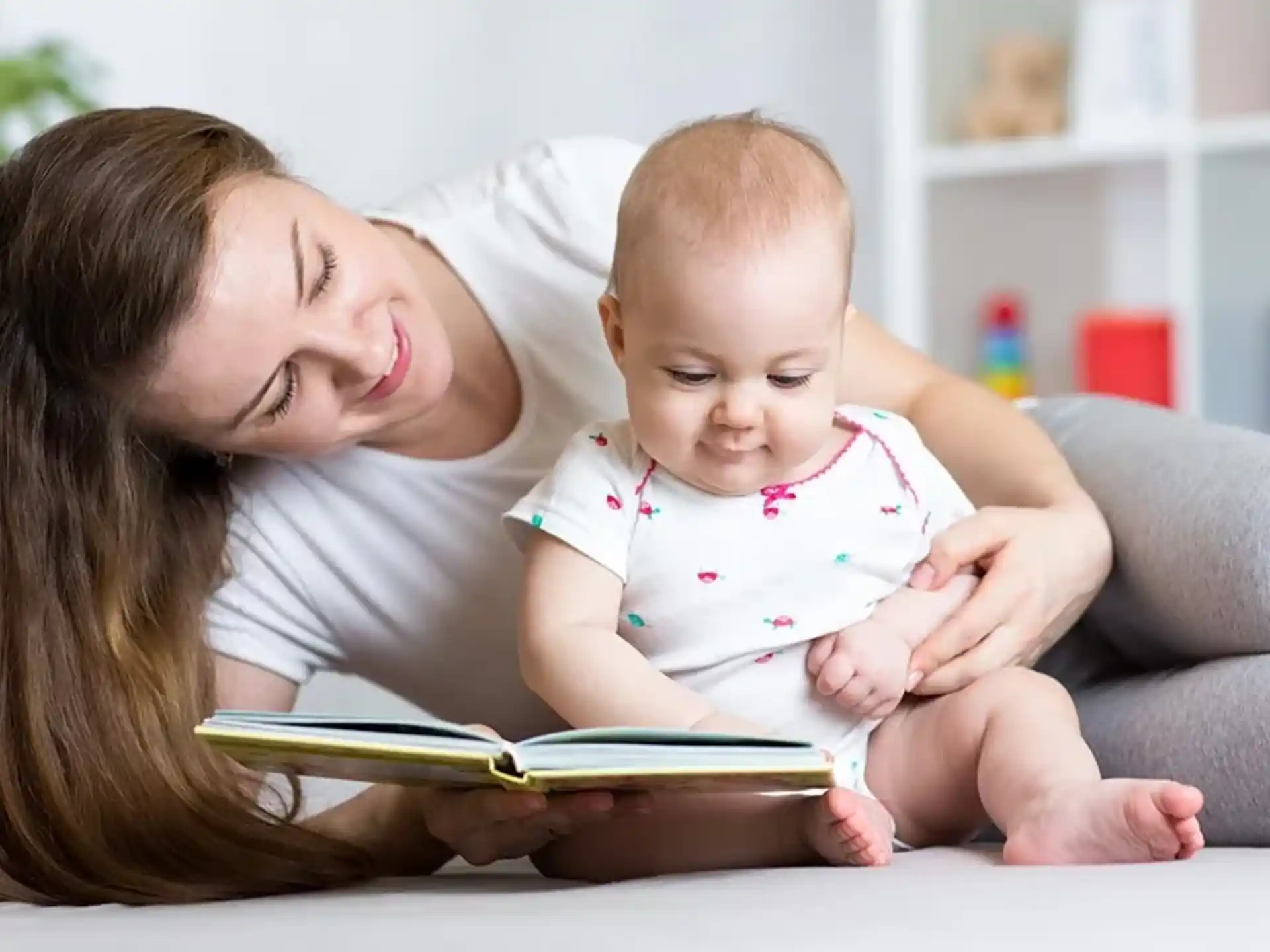 a person reading a book to a baby