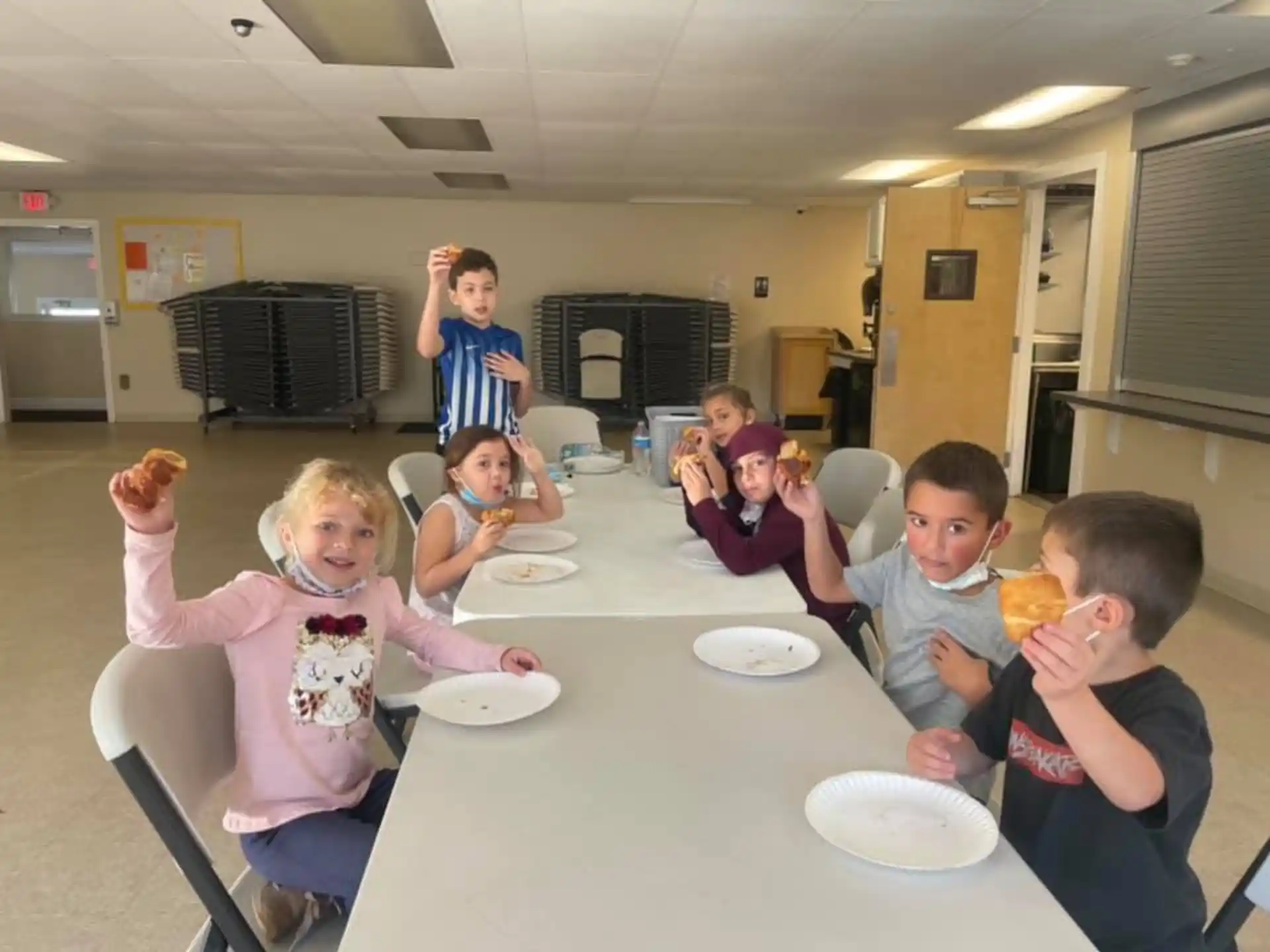 a group of children eating at a table