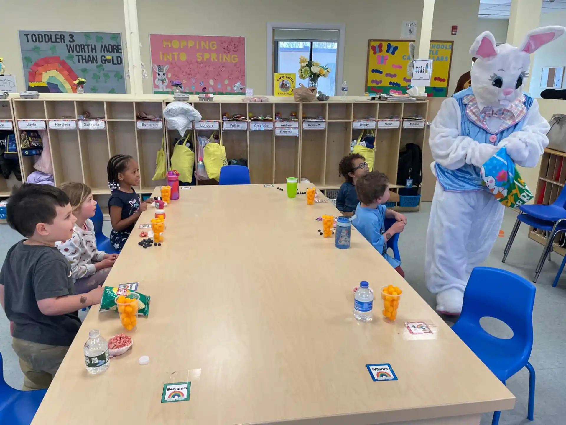 a group of children sitting at a table with toys