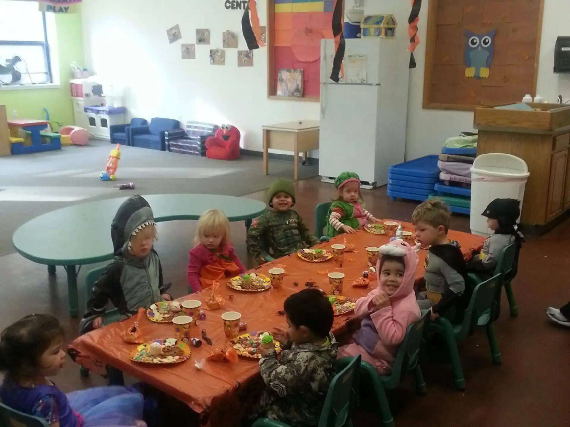 a group of children sitting around a table eating
