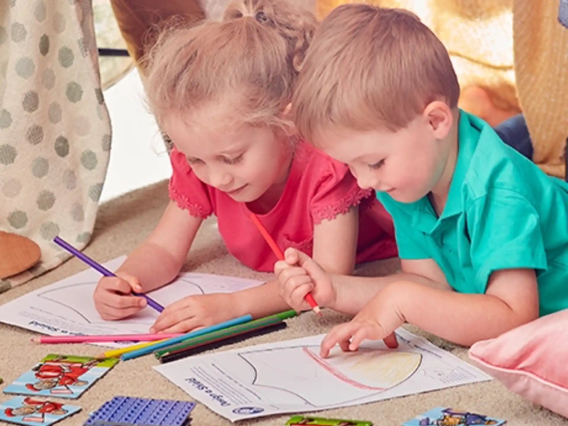 a couple of children coloring on paper