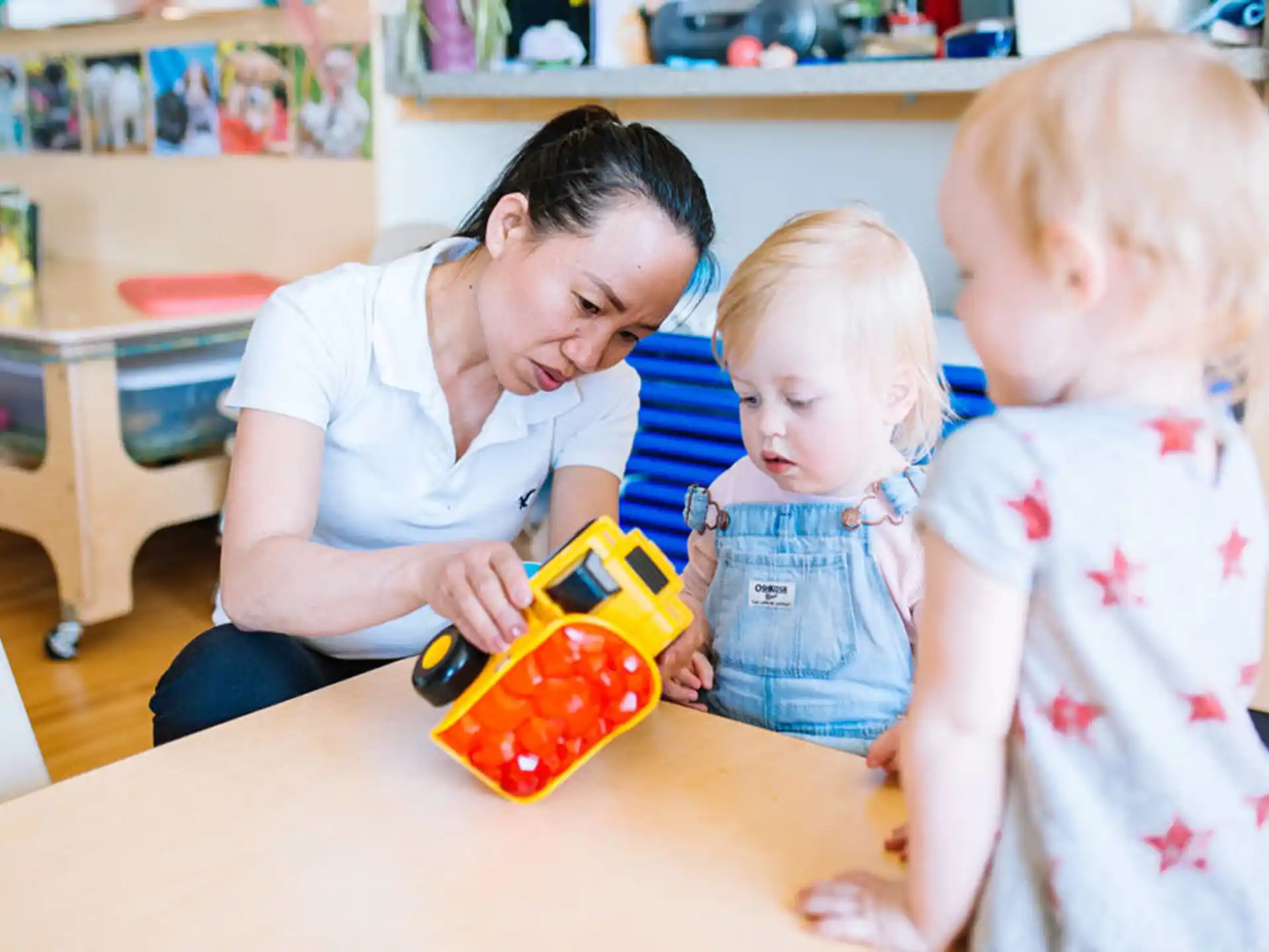 a person and two children playing with a toy
