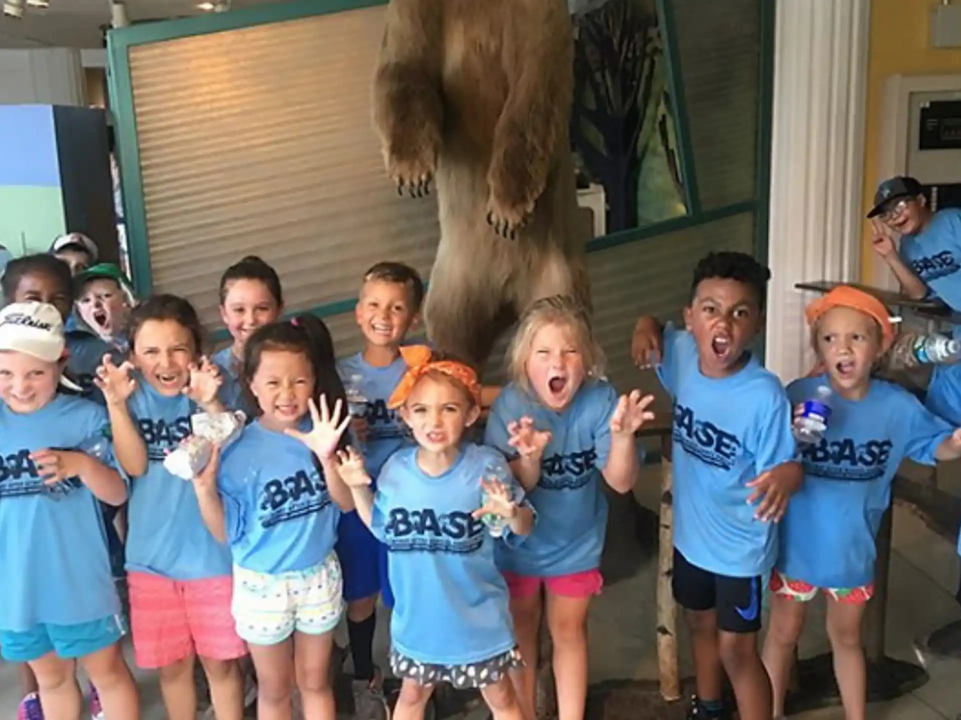 a group of children posing for a photo with a person in a garment