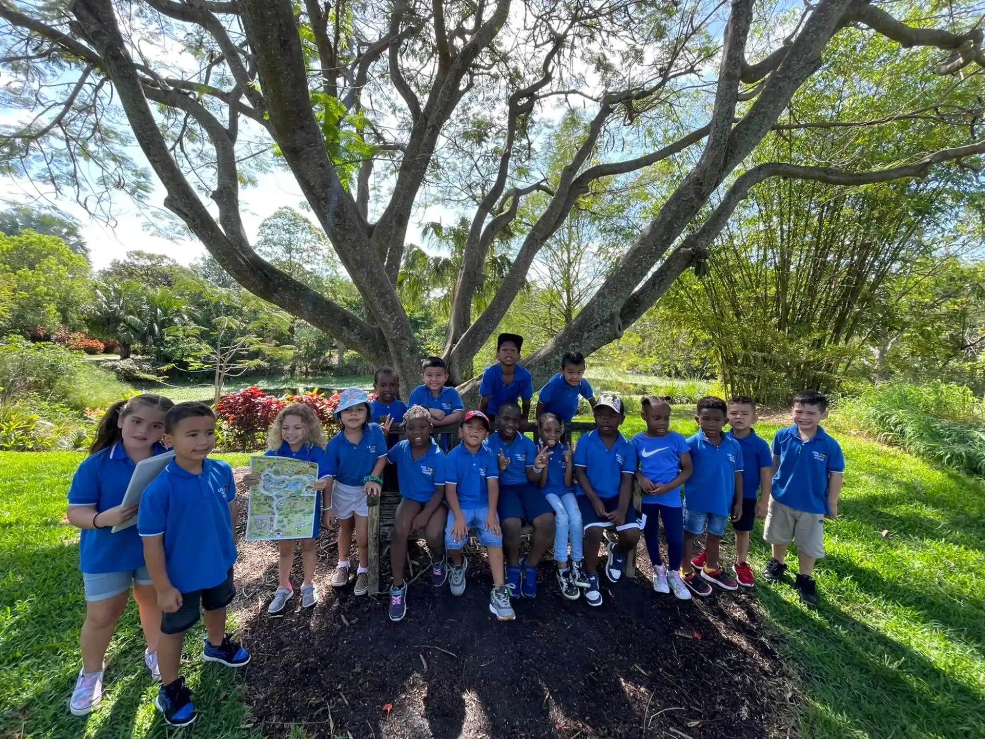 a group of people posing for a photo under a tree