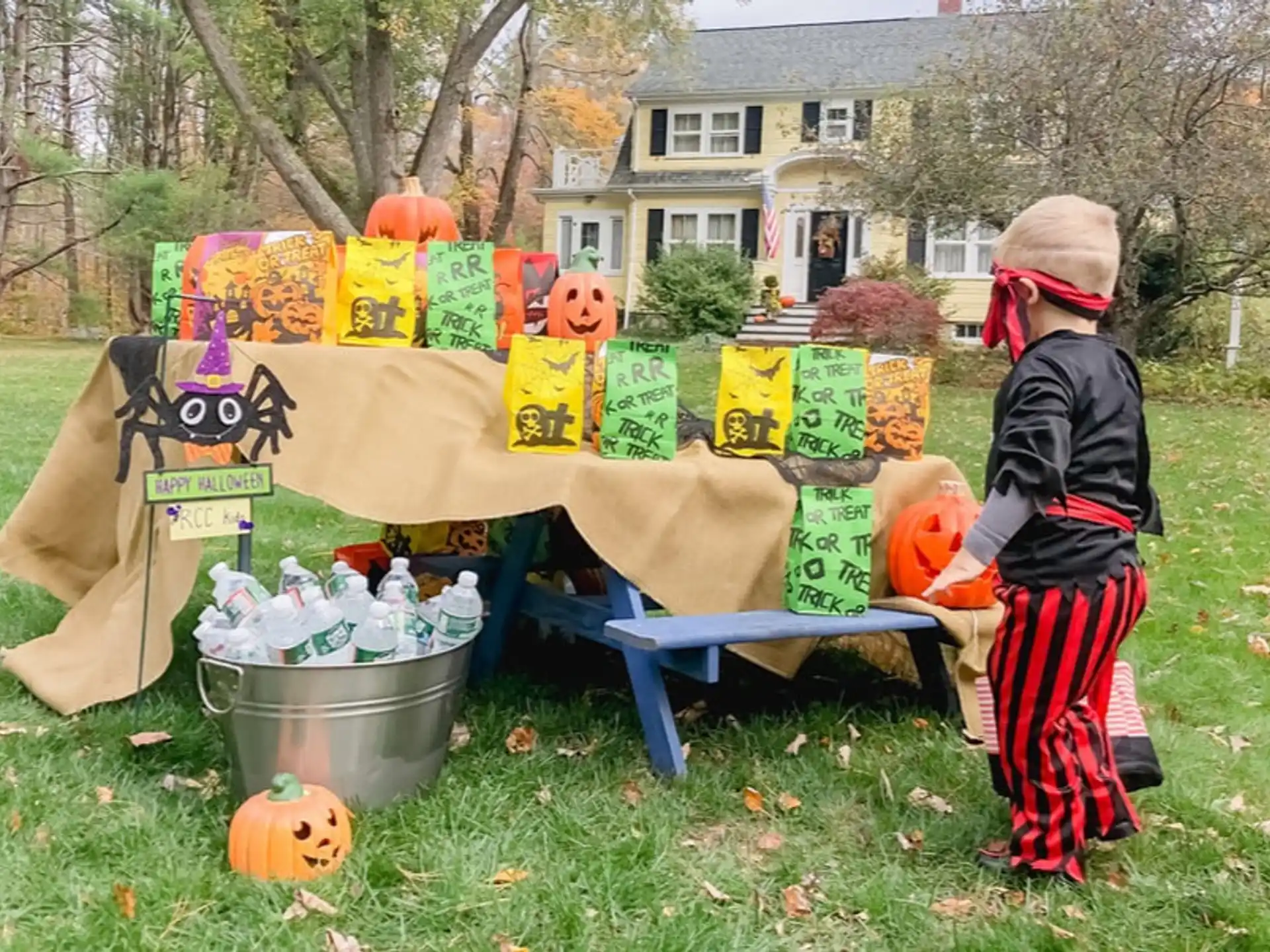 a child standing next to a table with food and drinks on it