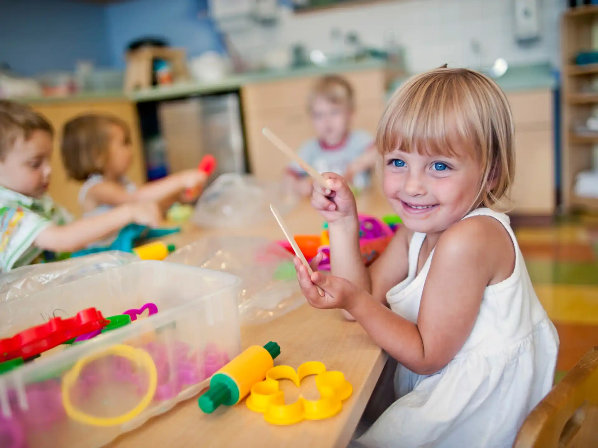 a group of children sitting at a table with toys