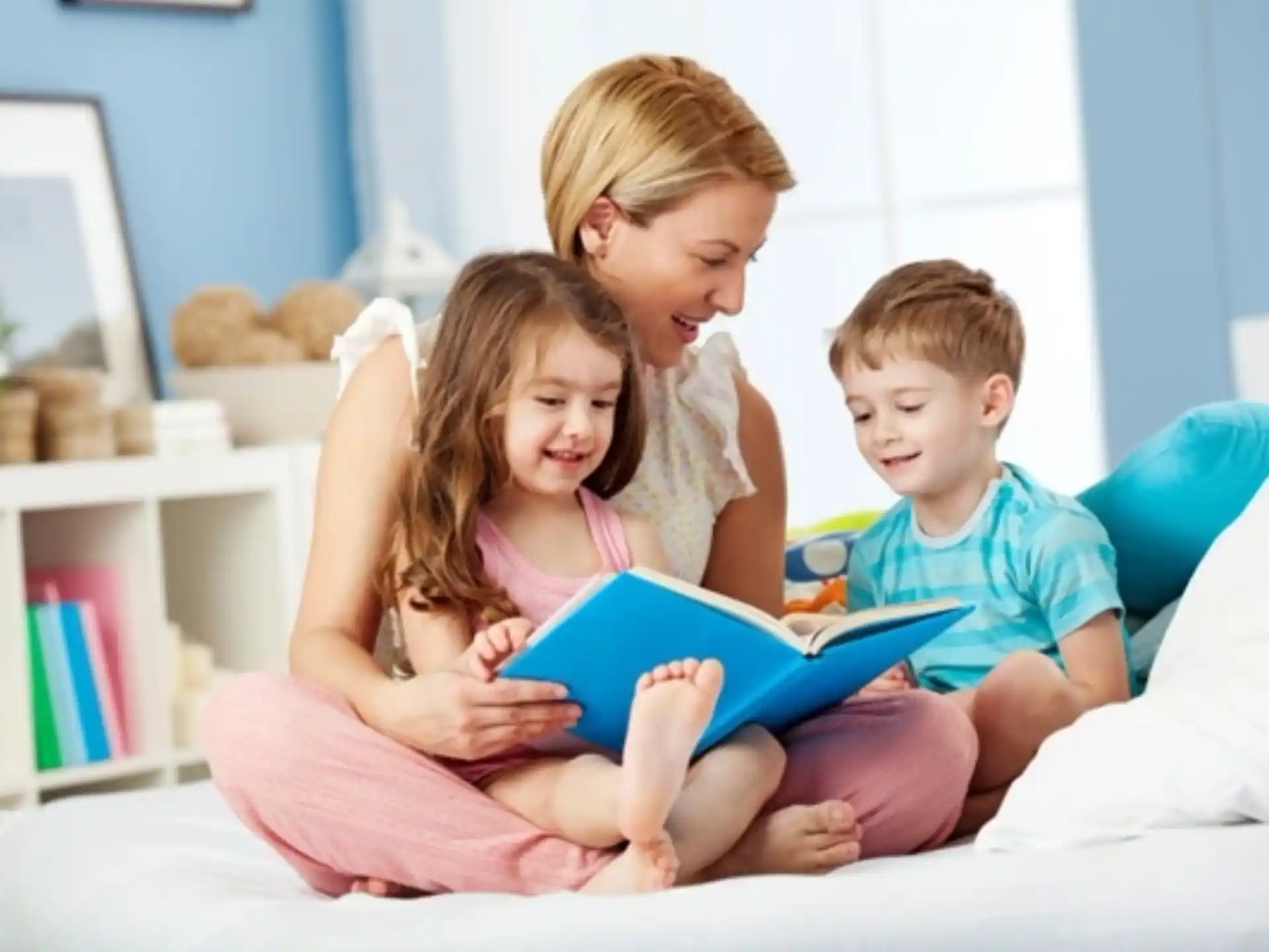 a person reading a book to a couple of children