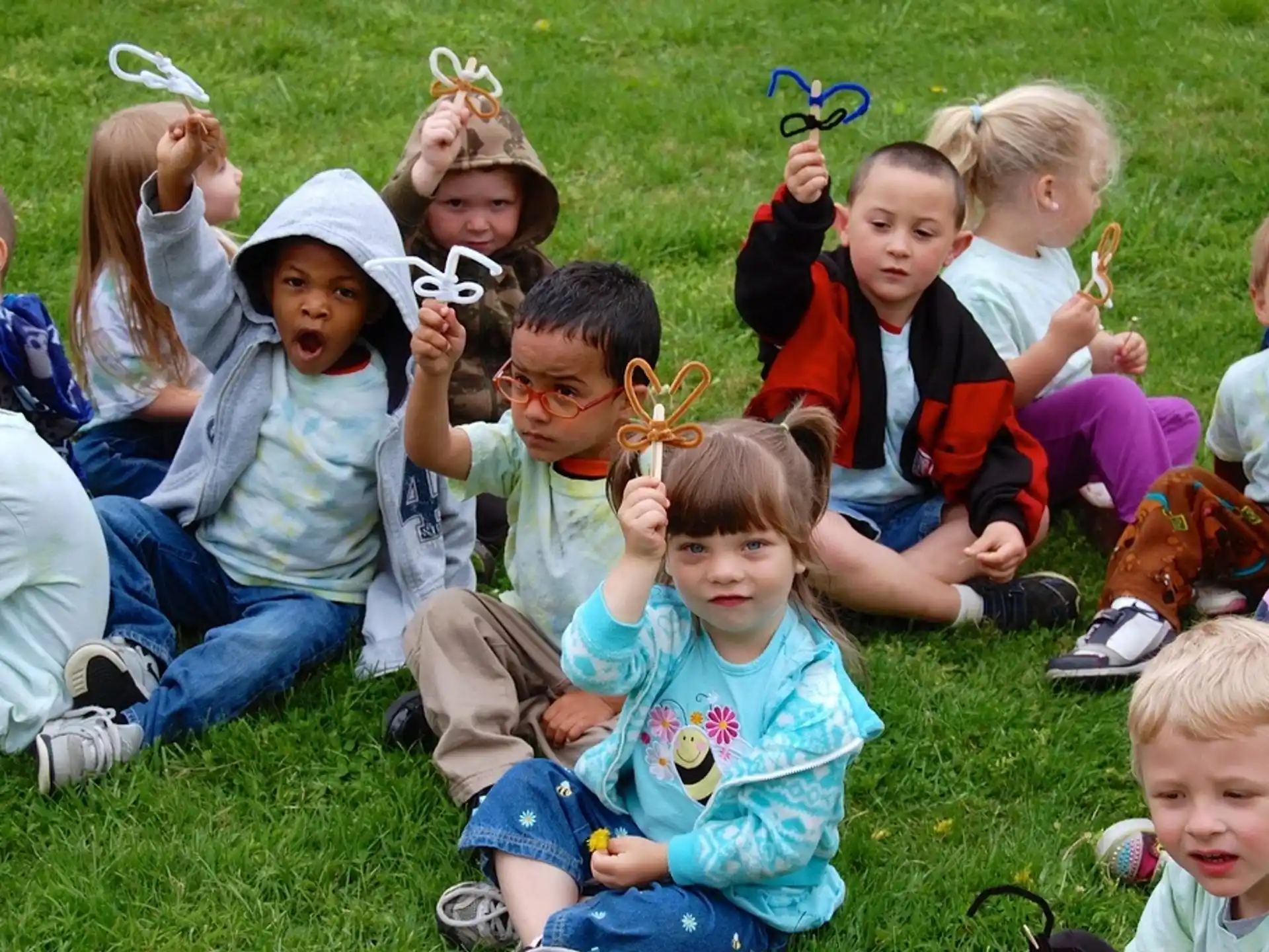 a group of children sitting on the grass