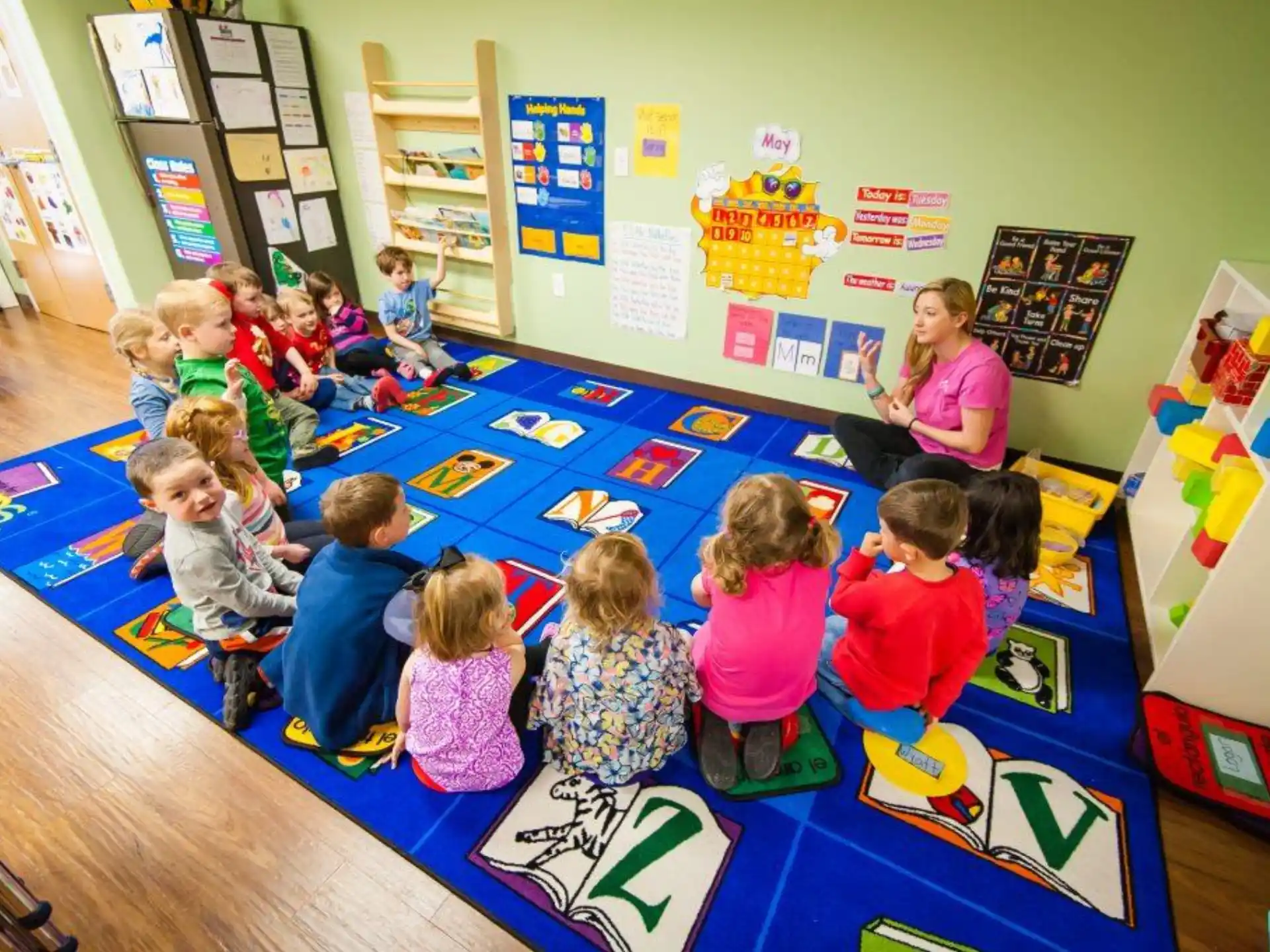 a group of children sitting on the floor in a classroom