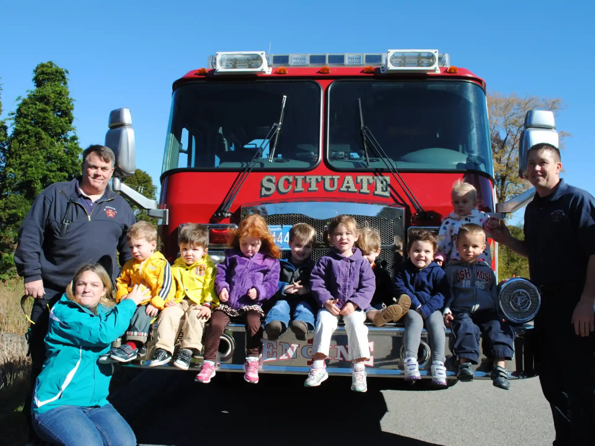 a group of people posing for a photo in front of a fire truck