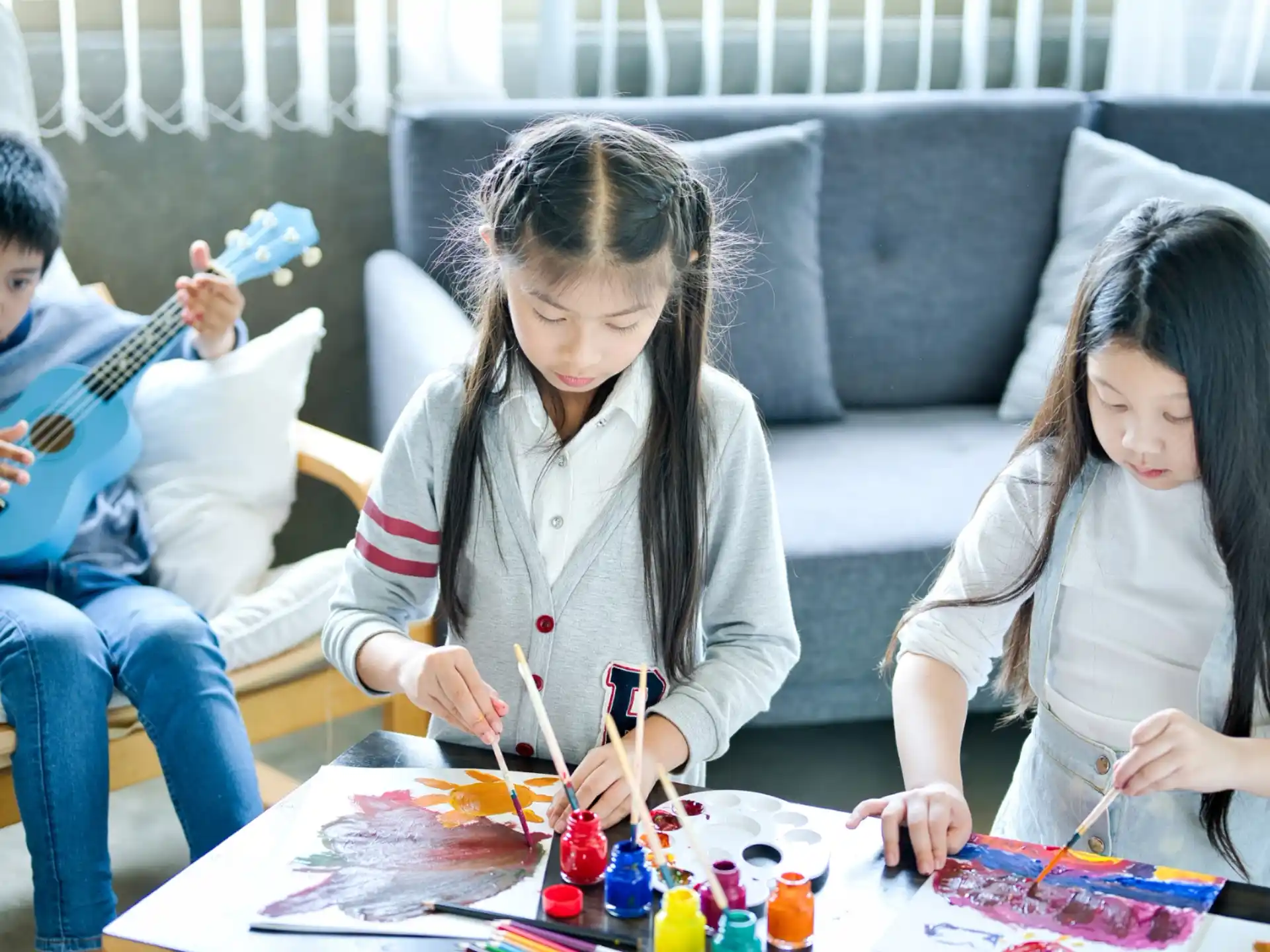a group of children sitting at a table playing a board game