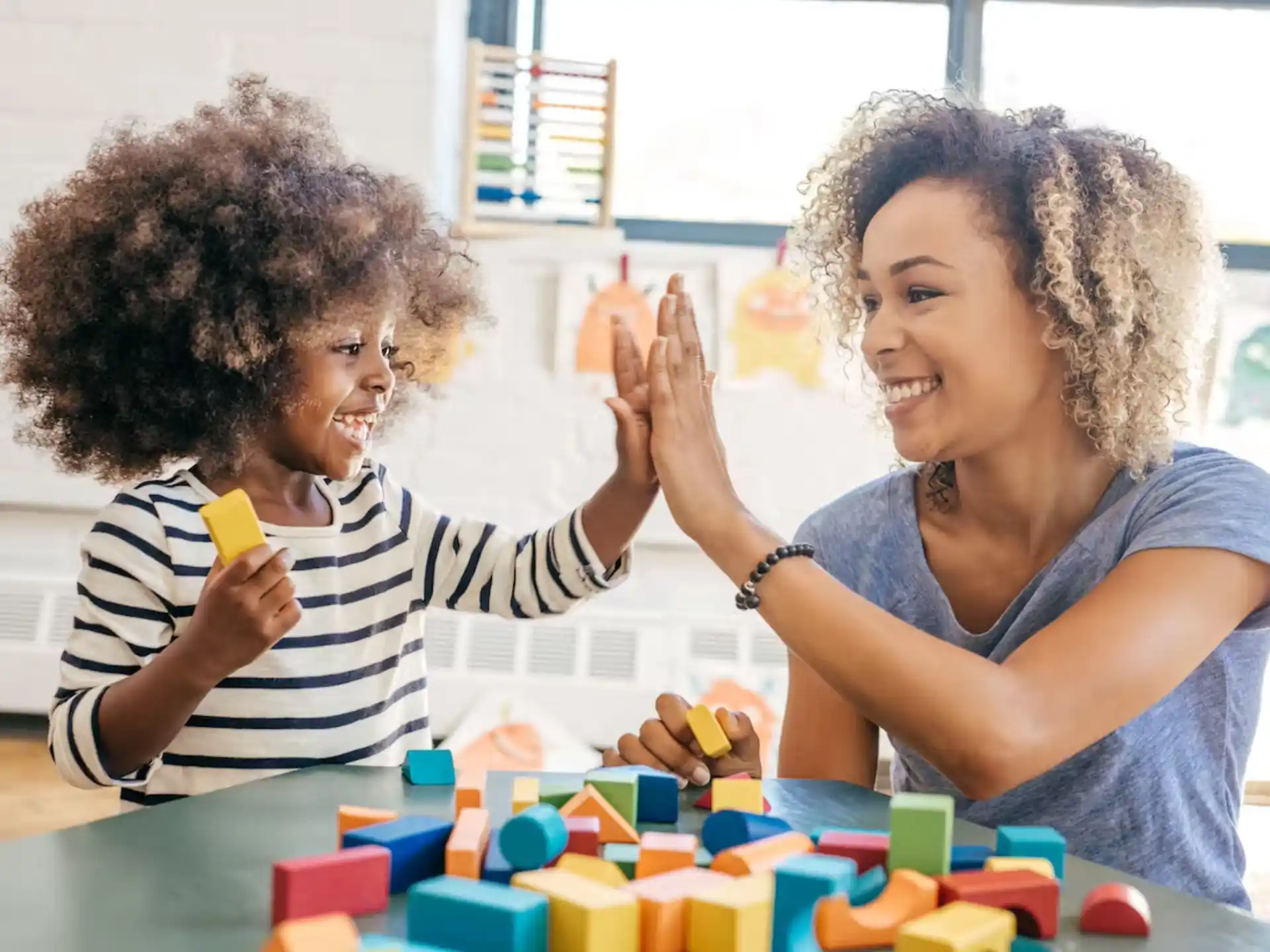 a person and a child playing with blocks