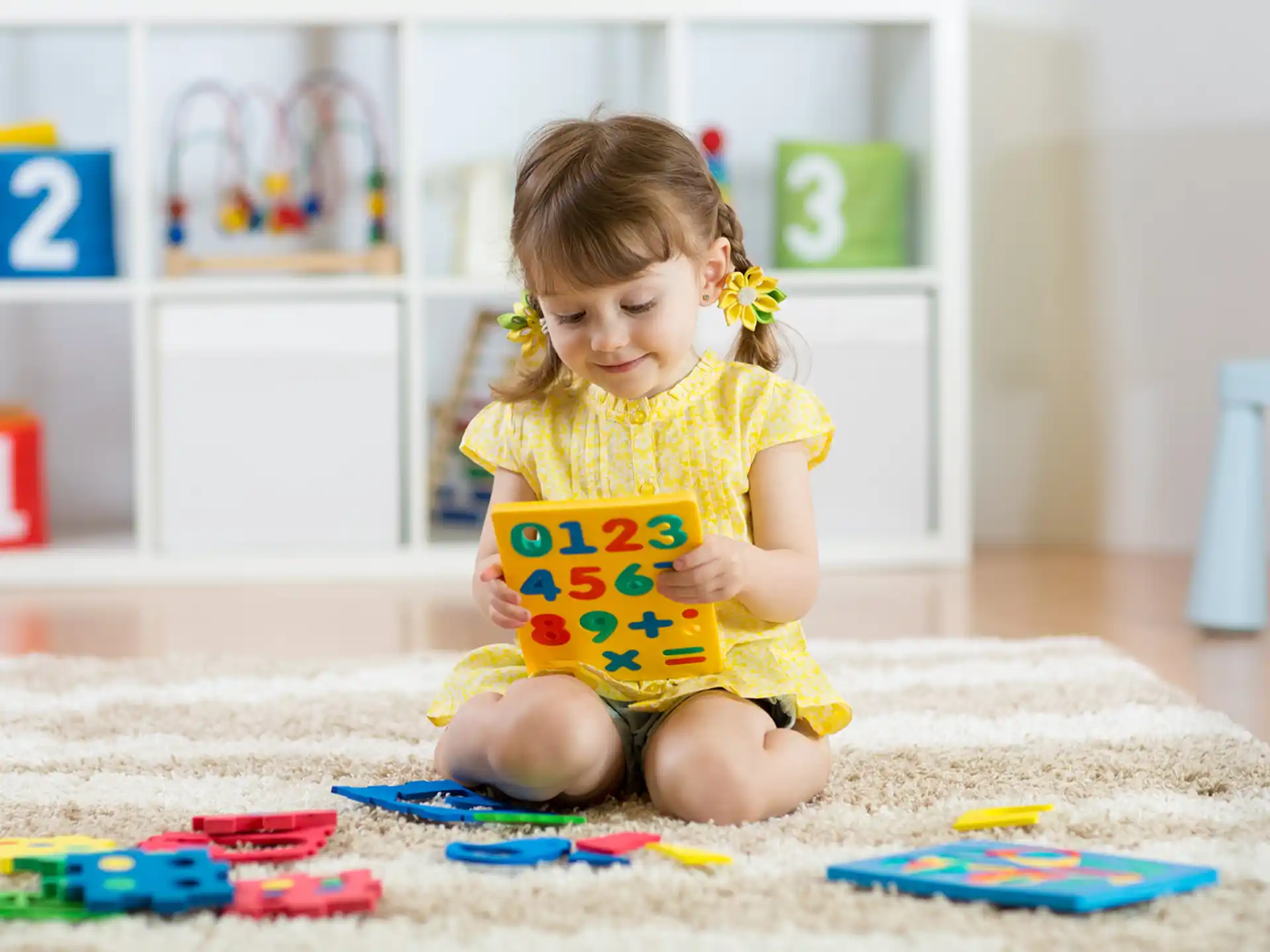 a girl sitting on the floor reading a book