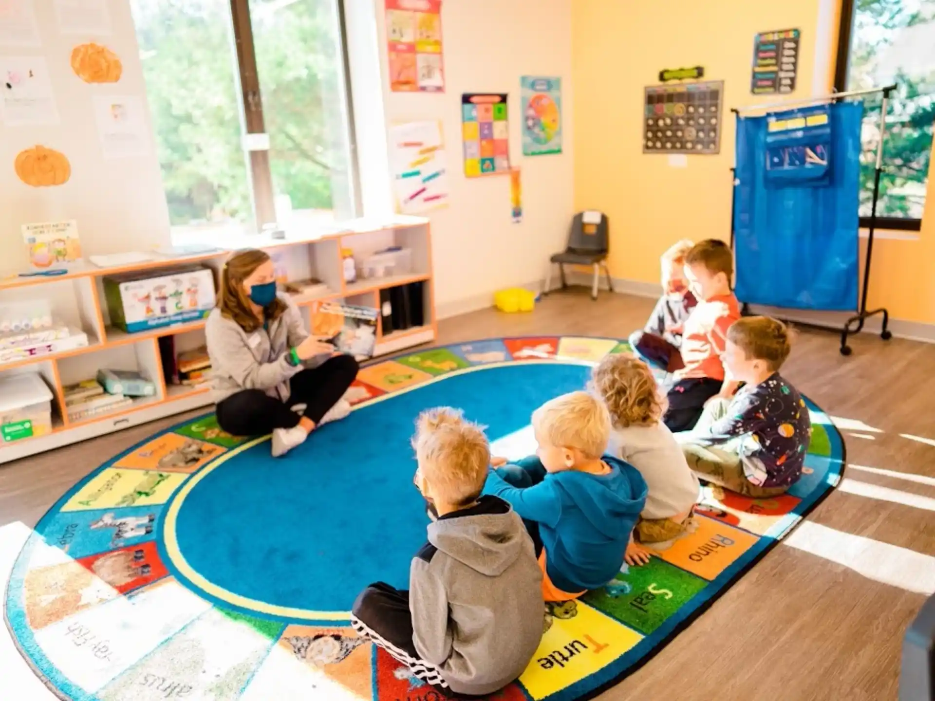 a group of children sitting on the floor in a classroom