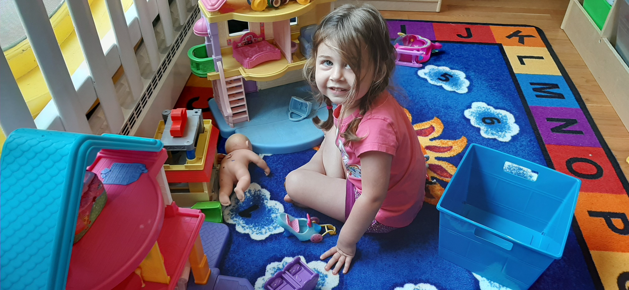 a girl and a baby playing on a blue and yellow play set