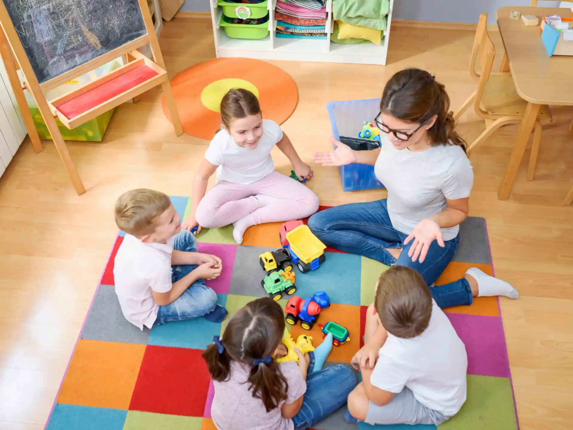 a person and several children playing with toys on the floor