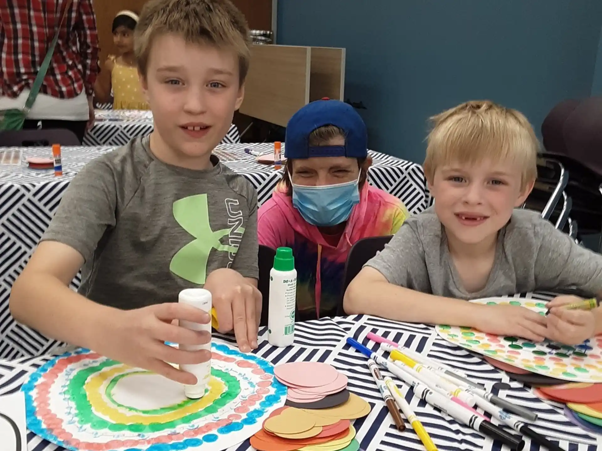 a group of boys sitting at a table with colorful plates