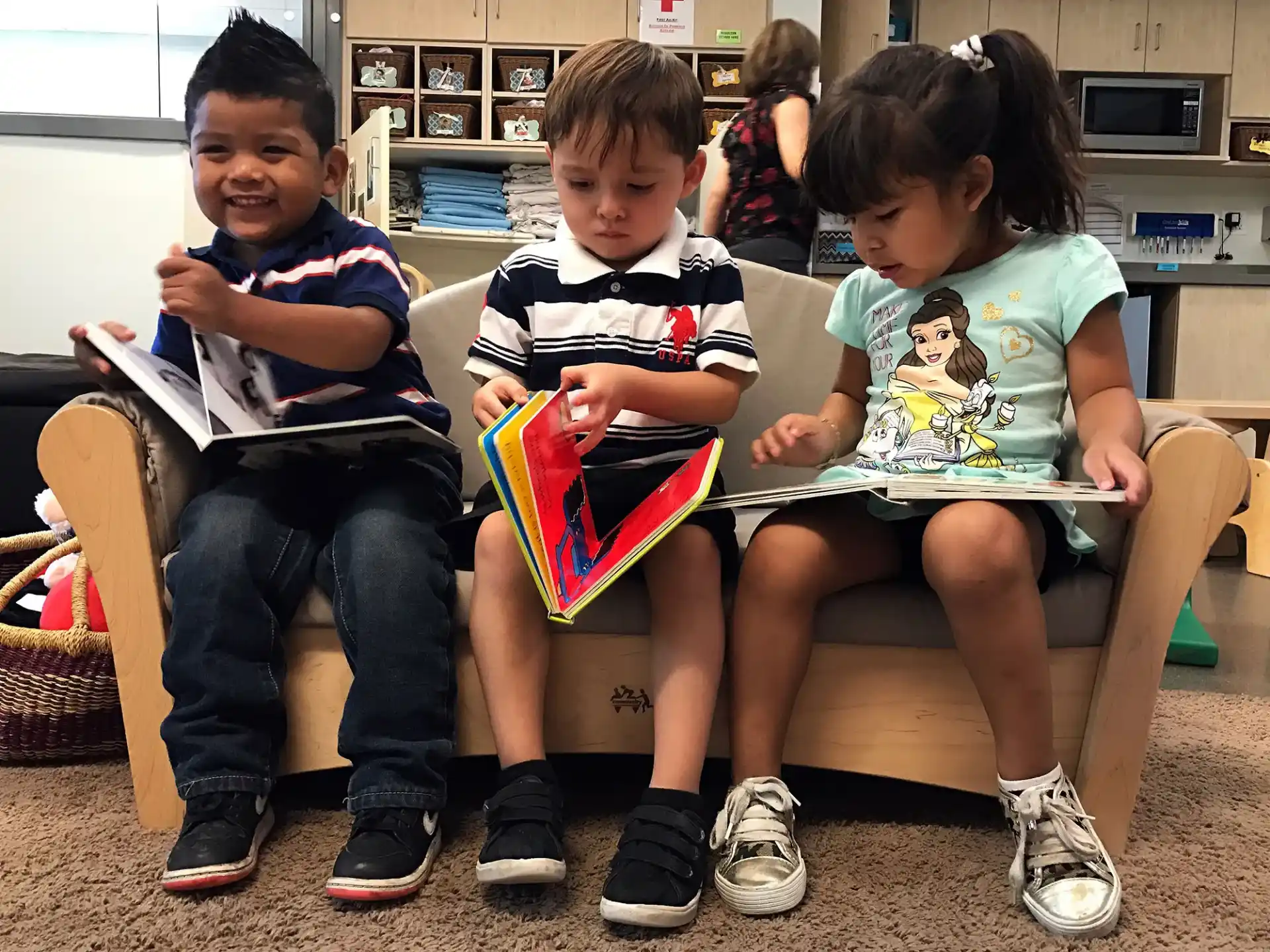 a group of children sitting on a bench reading books