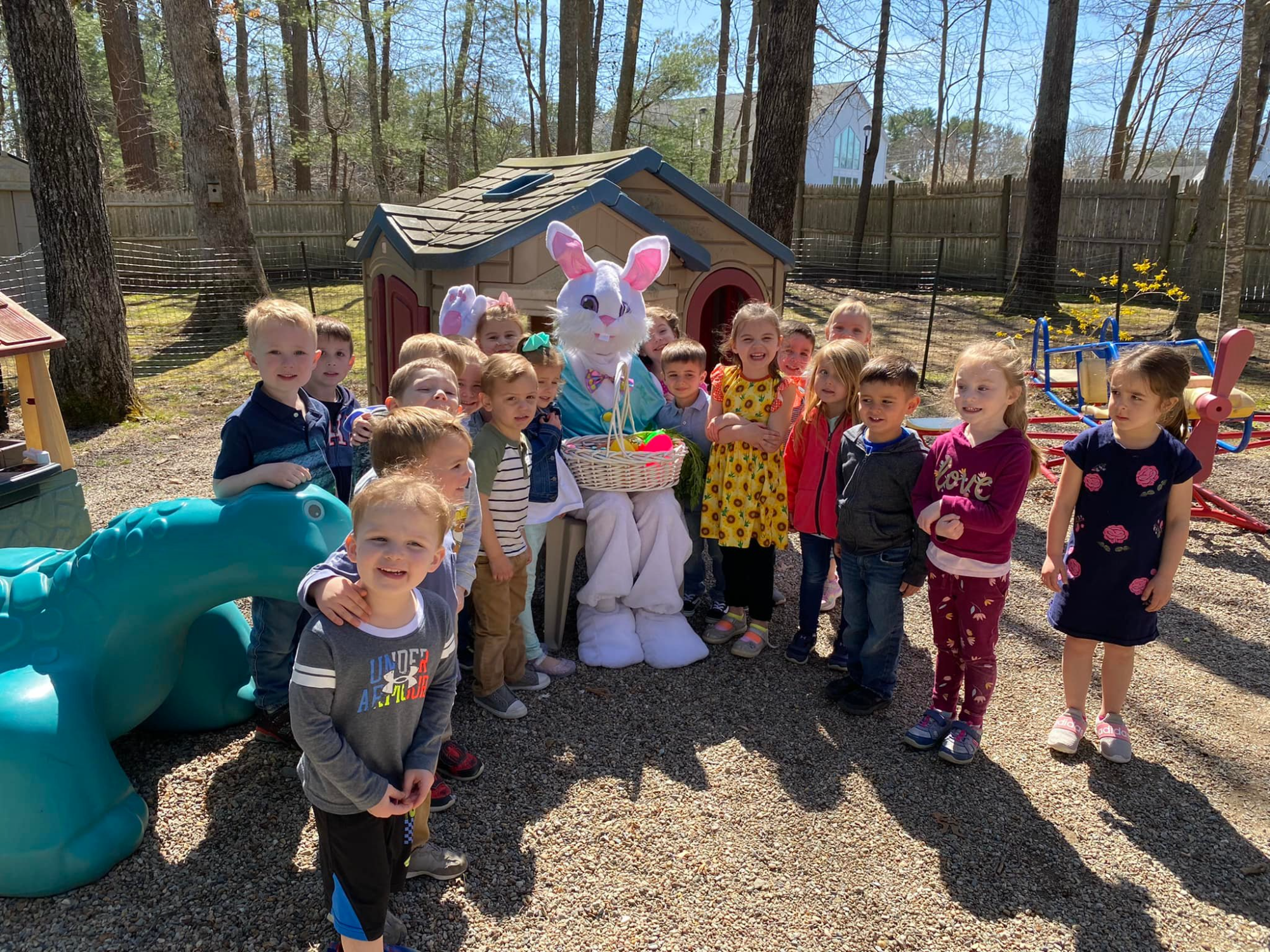a group of children posing with a person in a rabbit garment