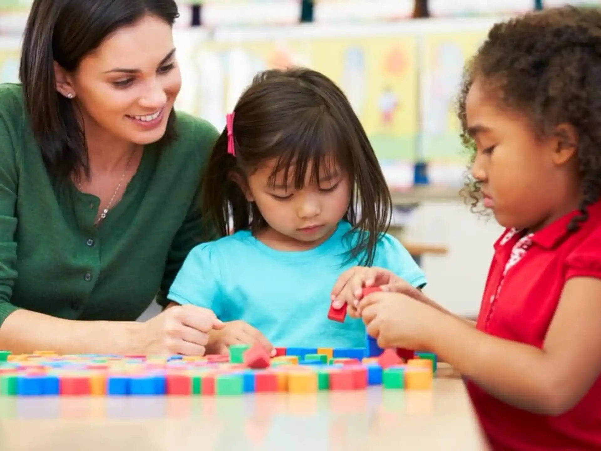 a person and a couple of children playing with a puzzle