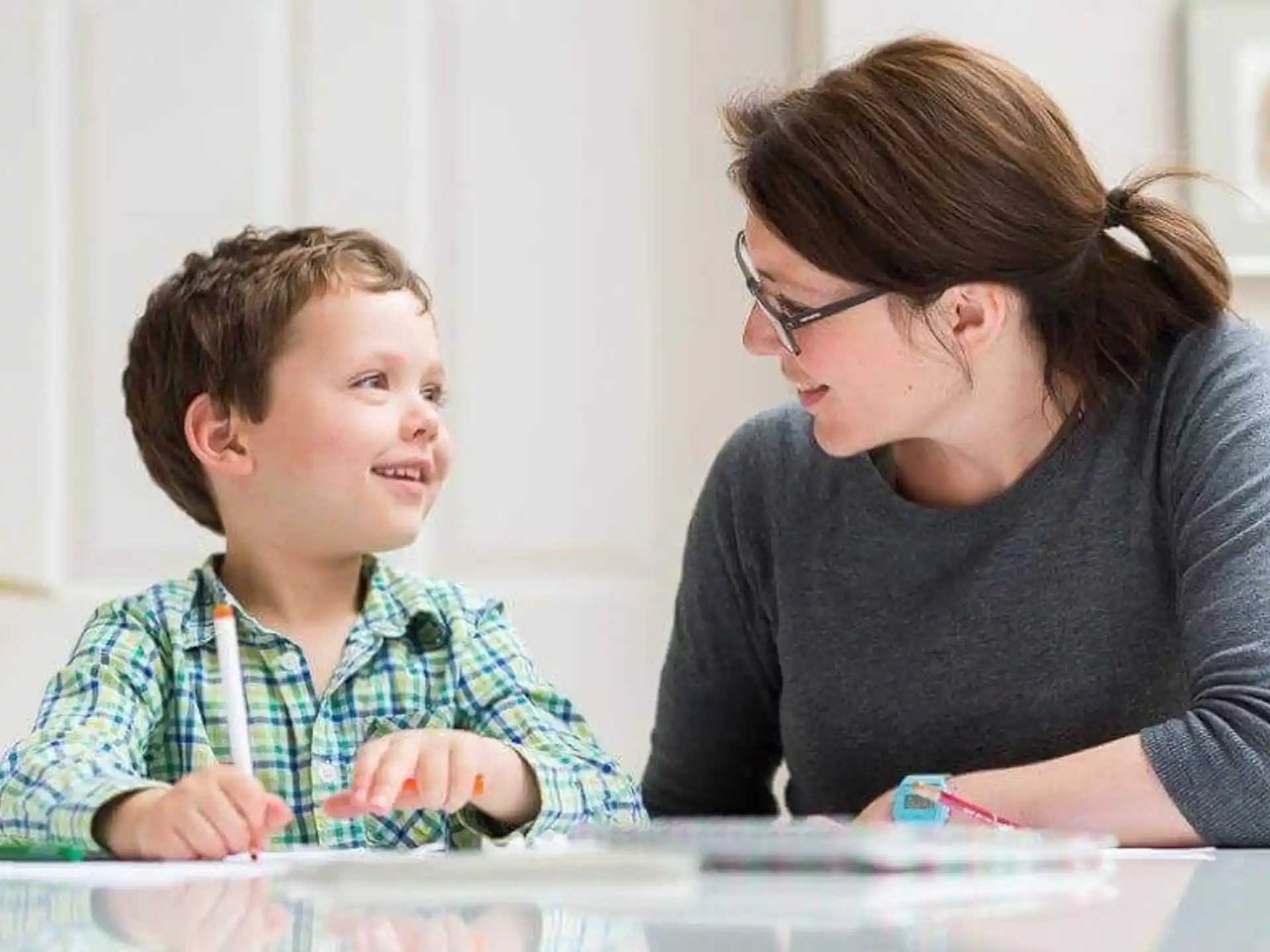 a woman and a child looking at a paper