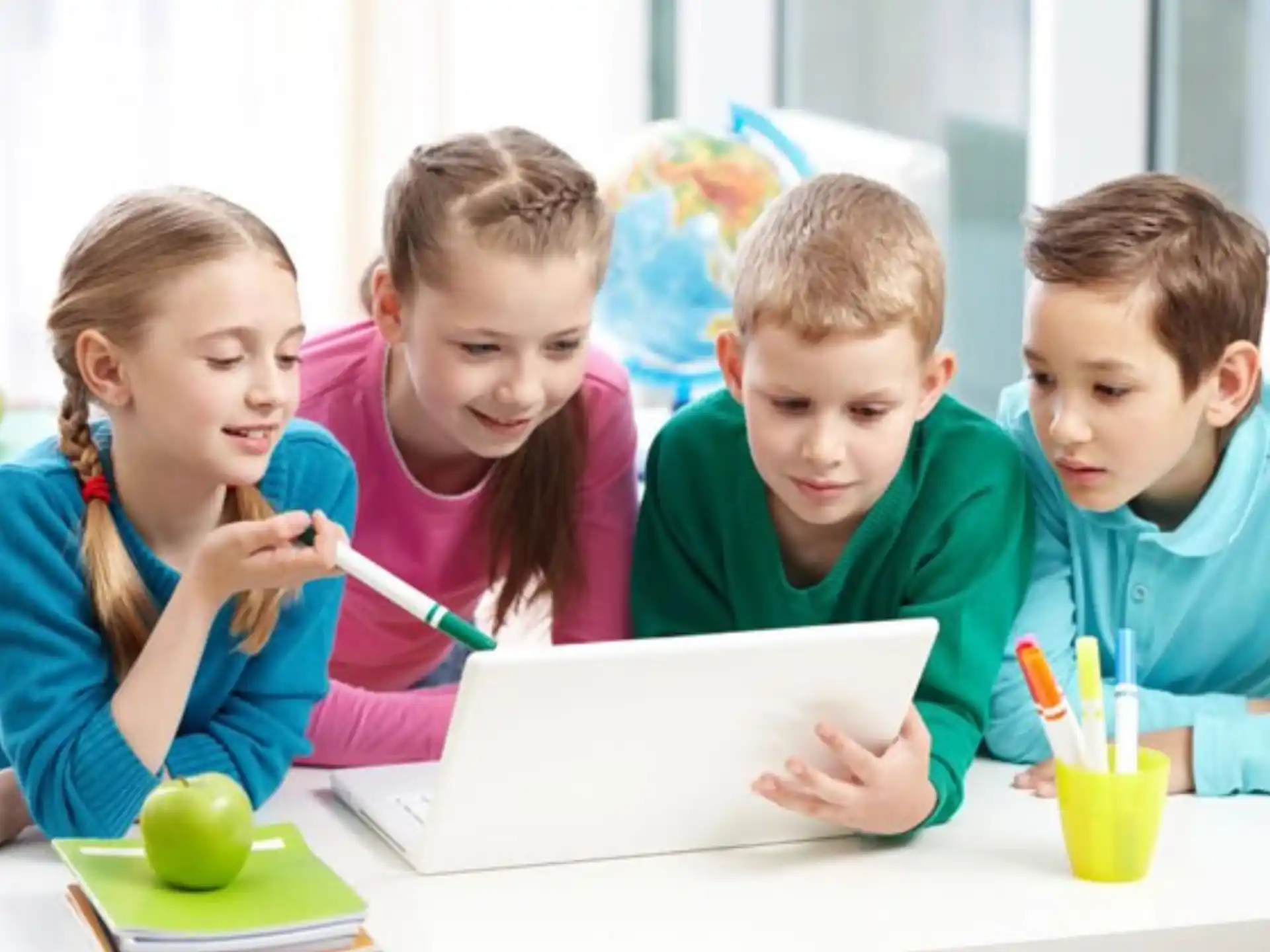 a group of children looking at a laptop