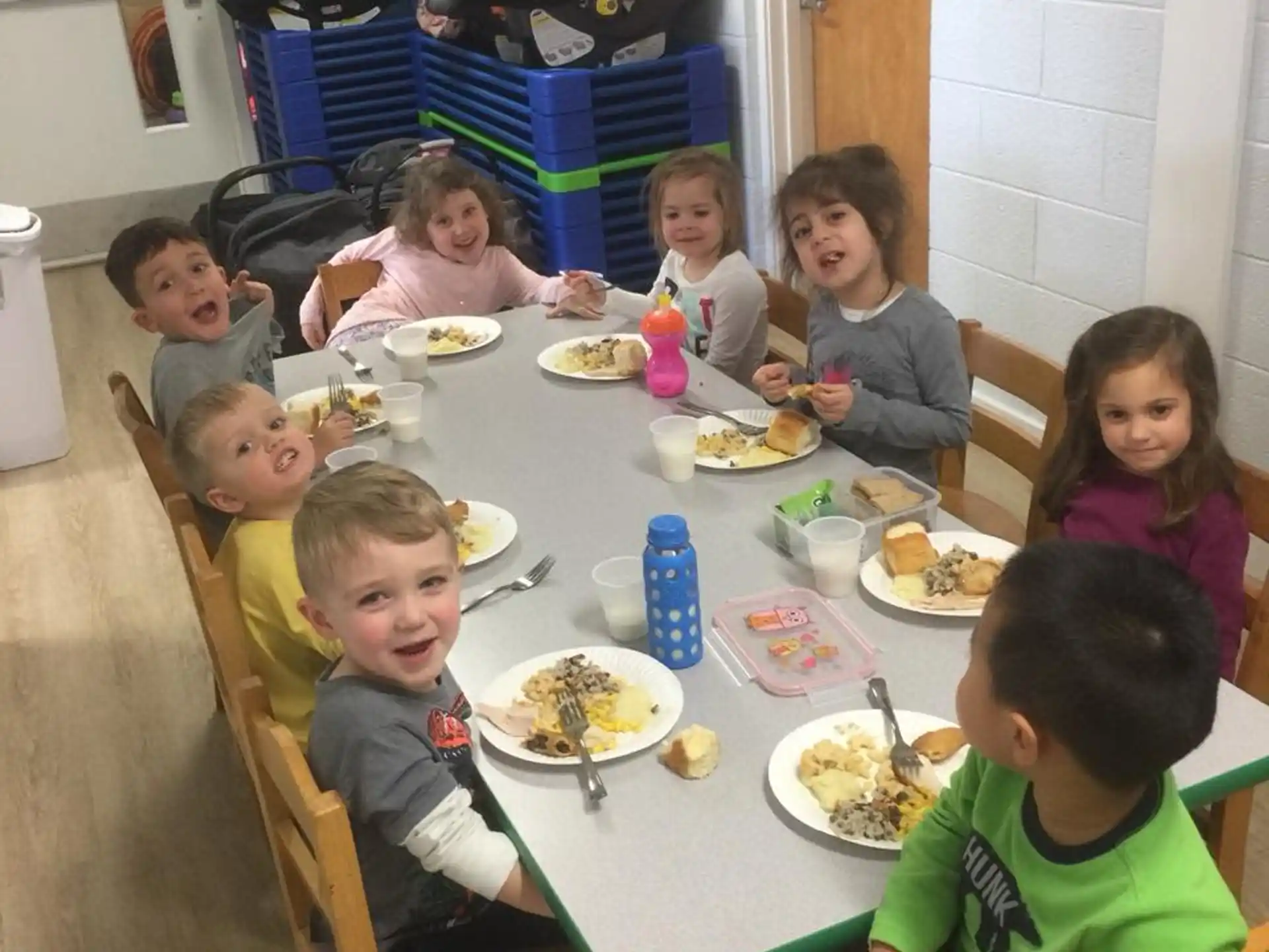 a group of children eating at a table