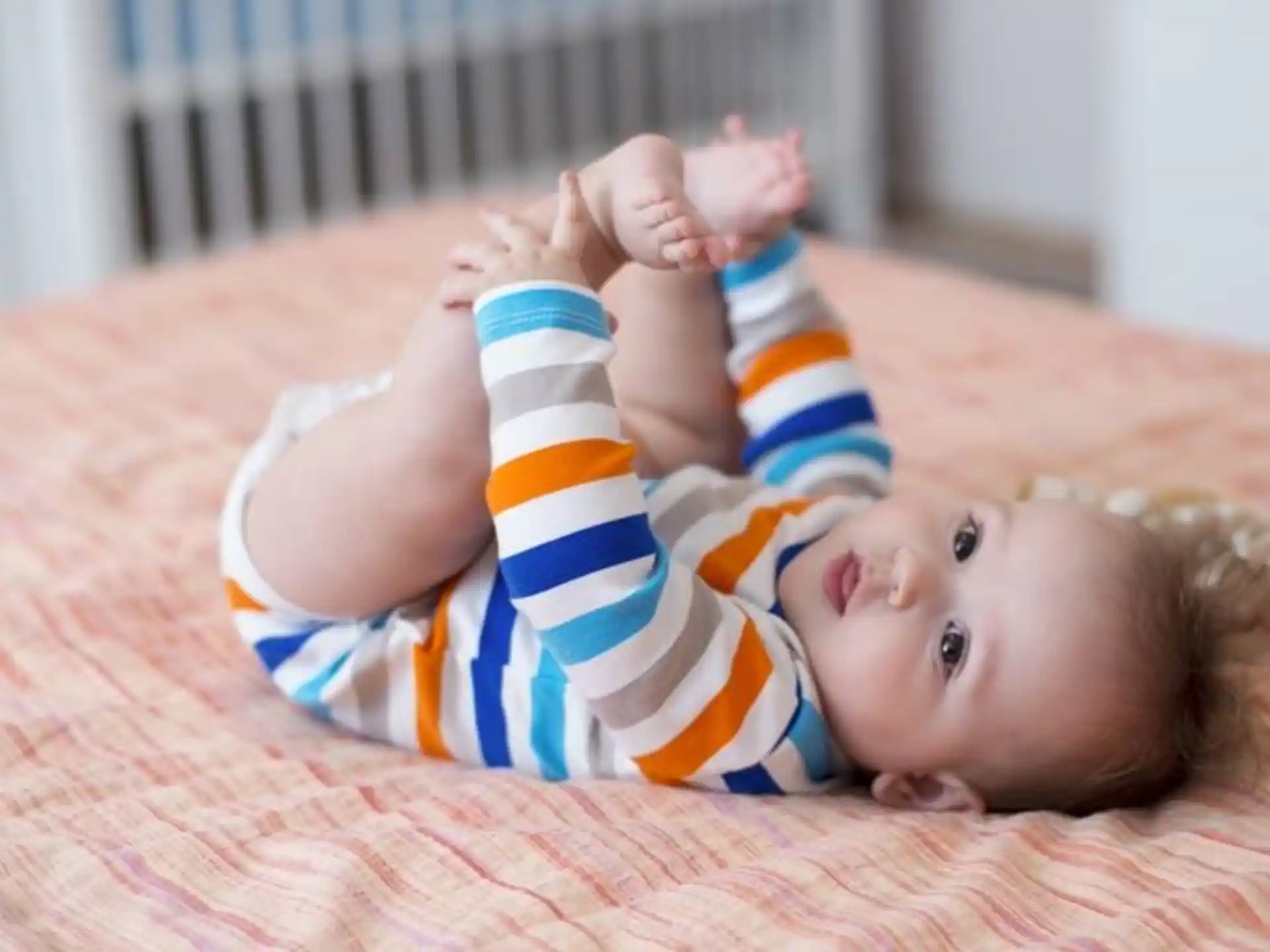 a baby lying on a bed
