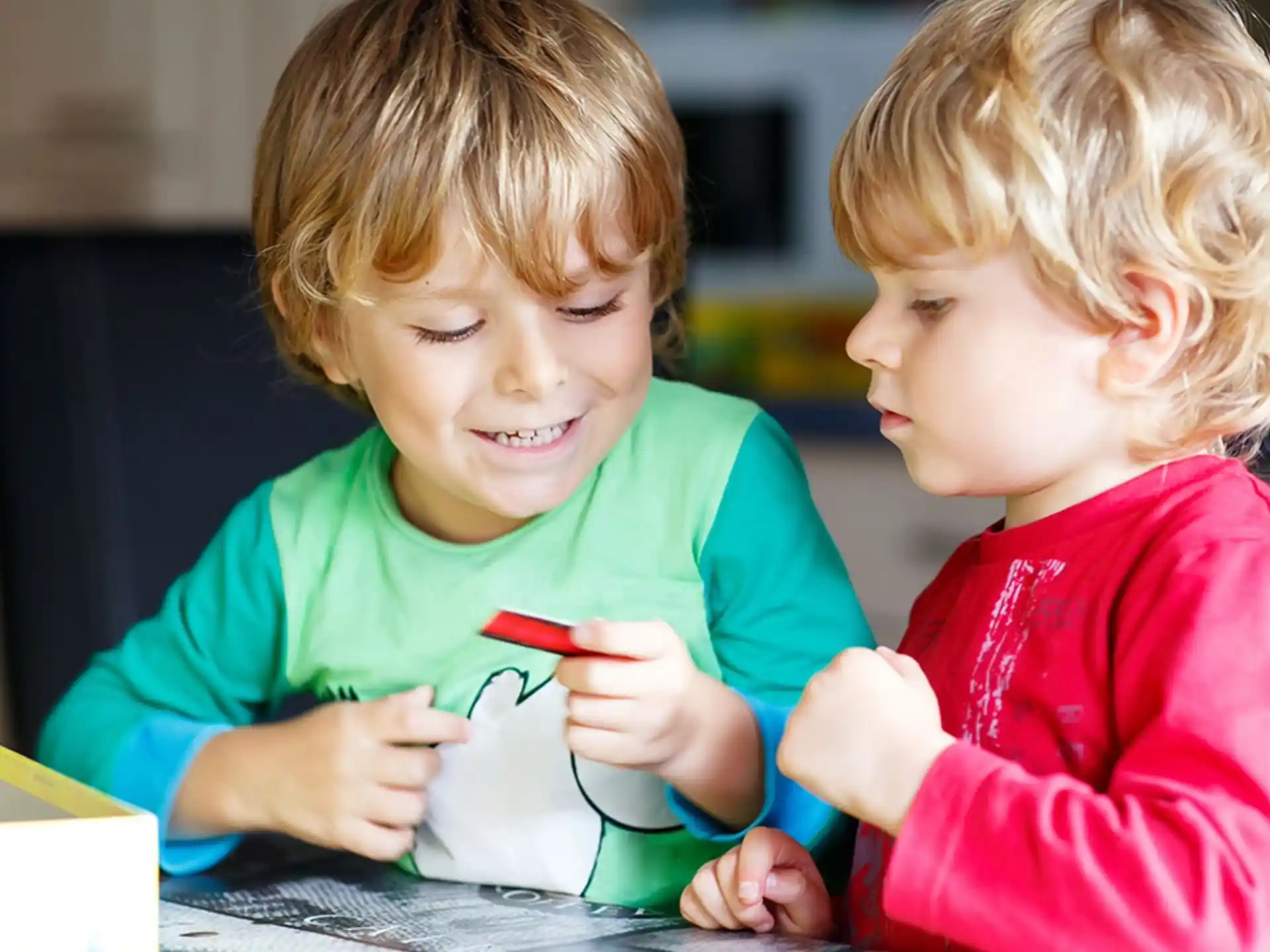 a couple of children looking at a paper