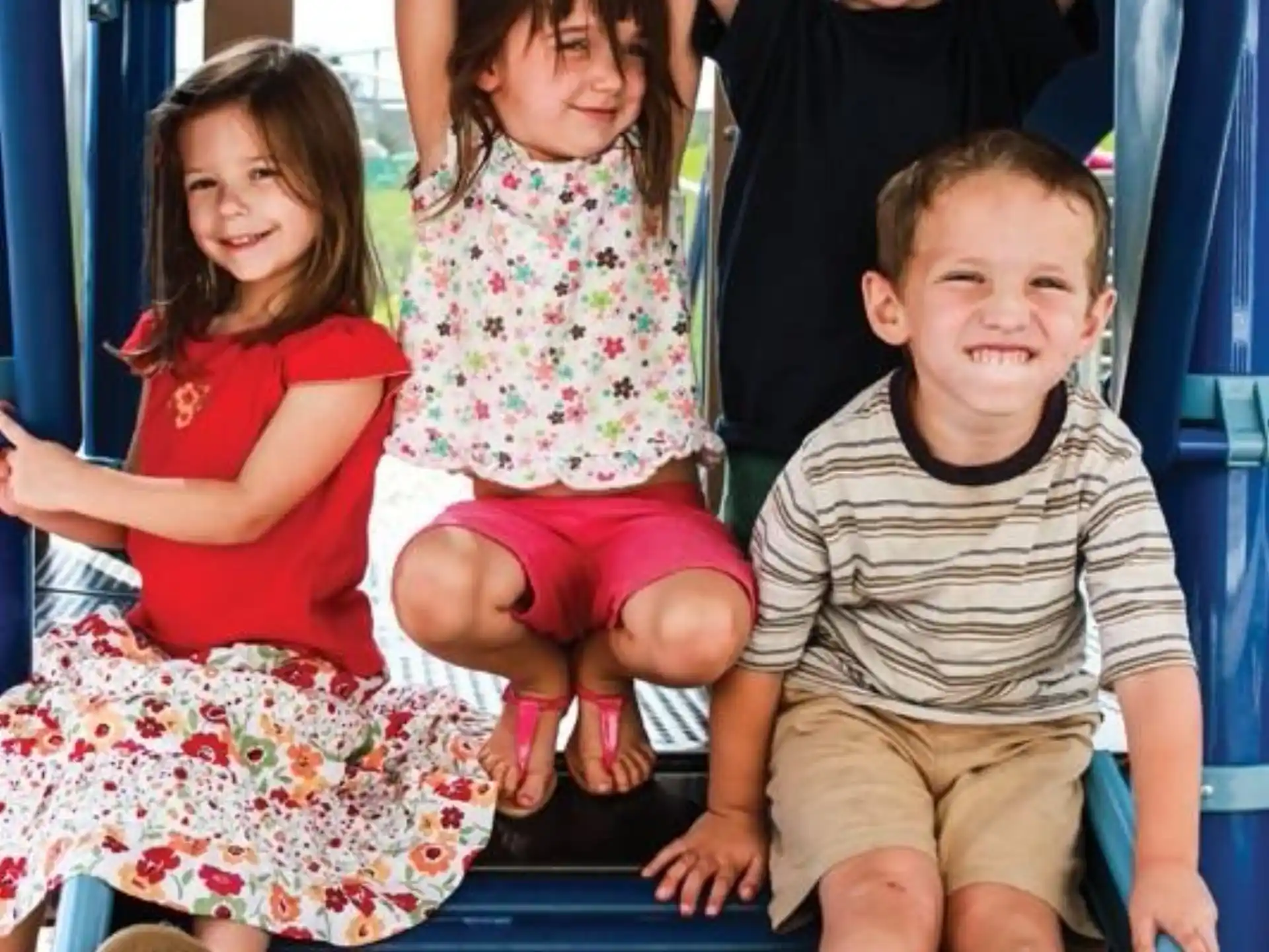 a group of children sitting on a blue slide
