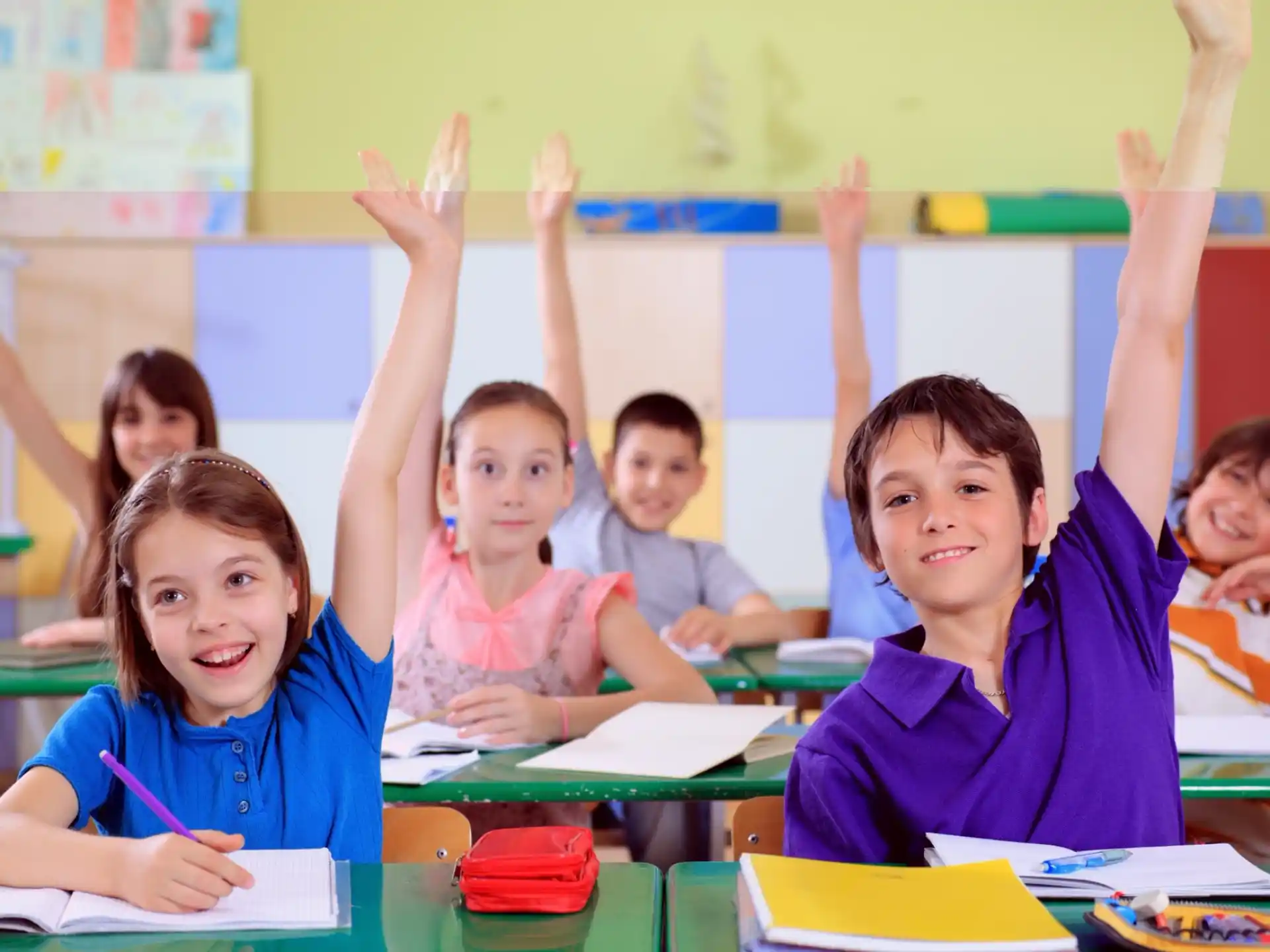 a group of children raising their hands