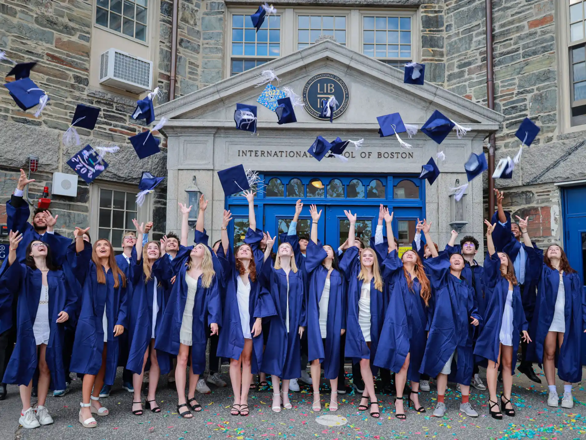a group of girls in blue graduation gowns and caps