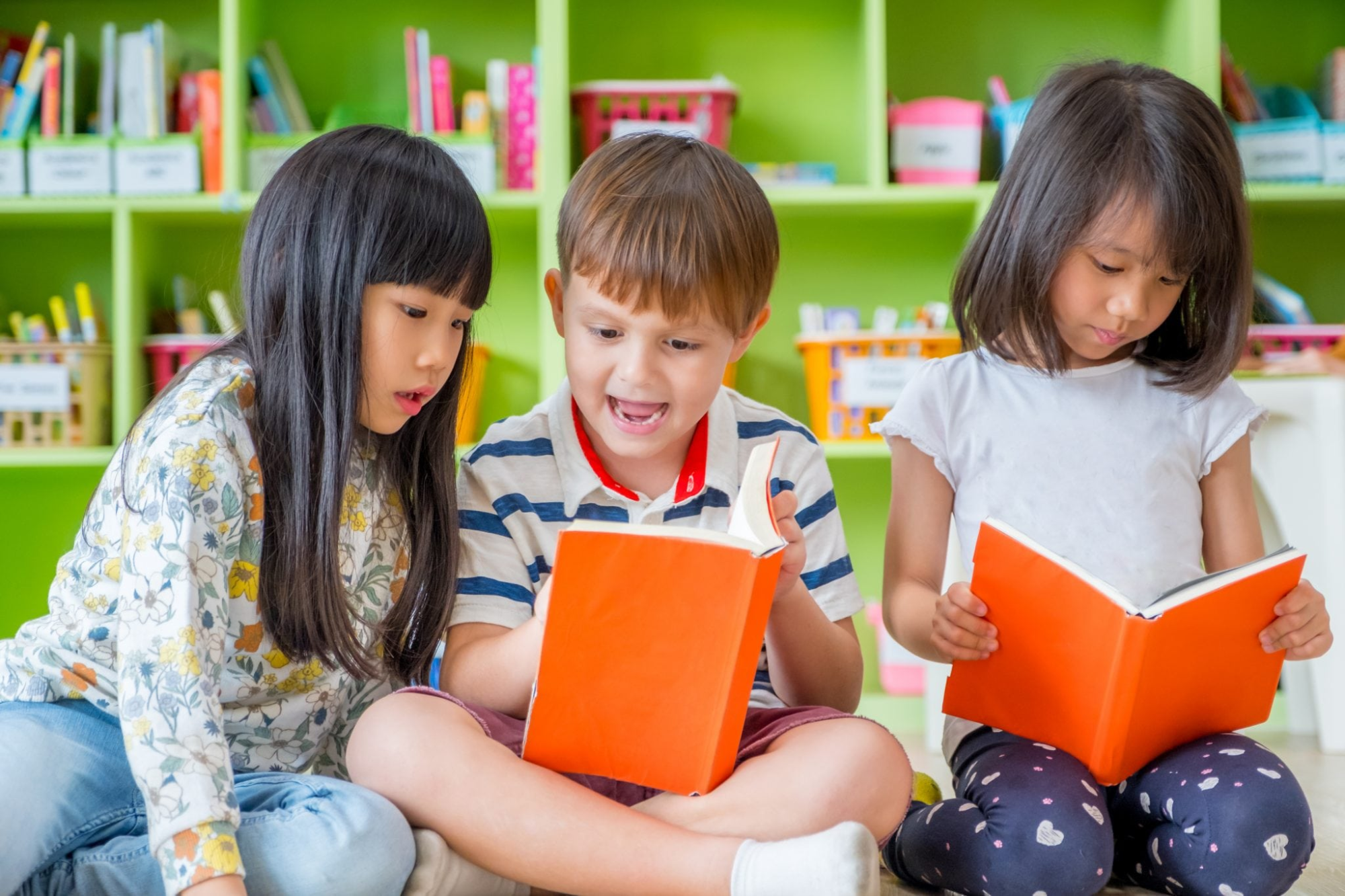 a group of children sitting on the floor reading books